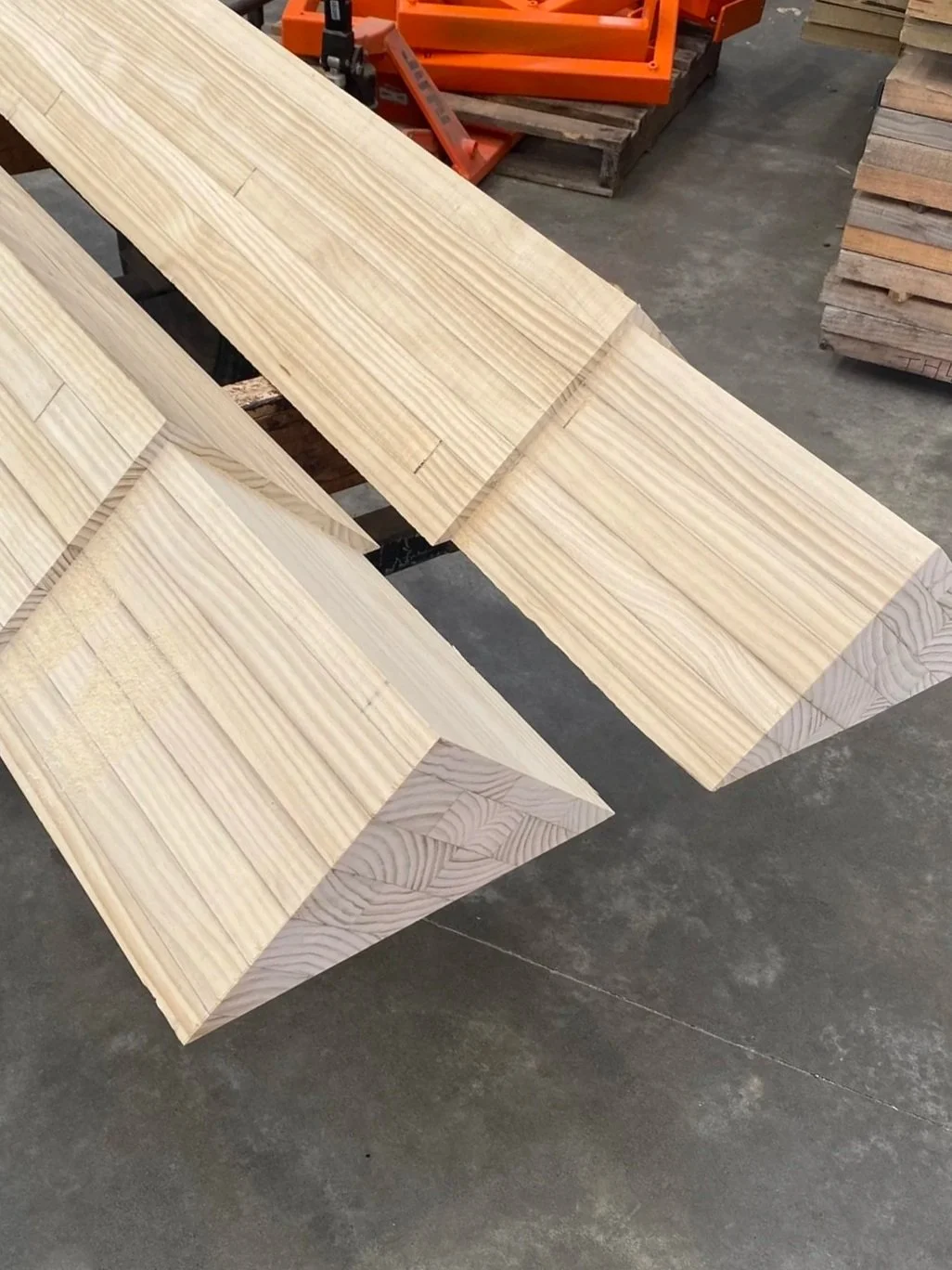 Large, rectangular glulam timber beams with a natural light wood finish.