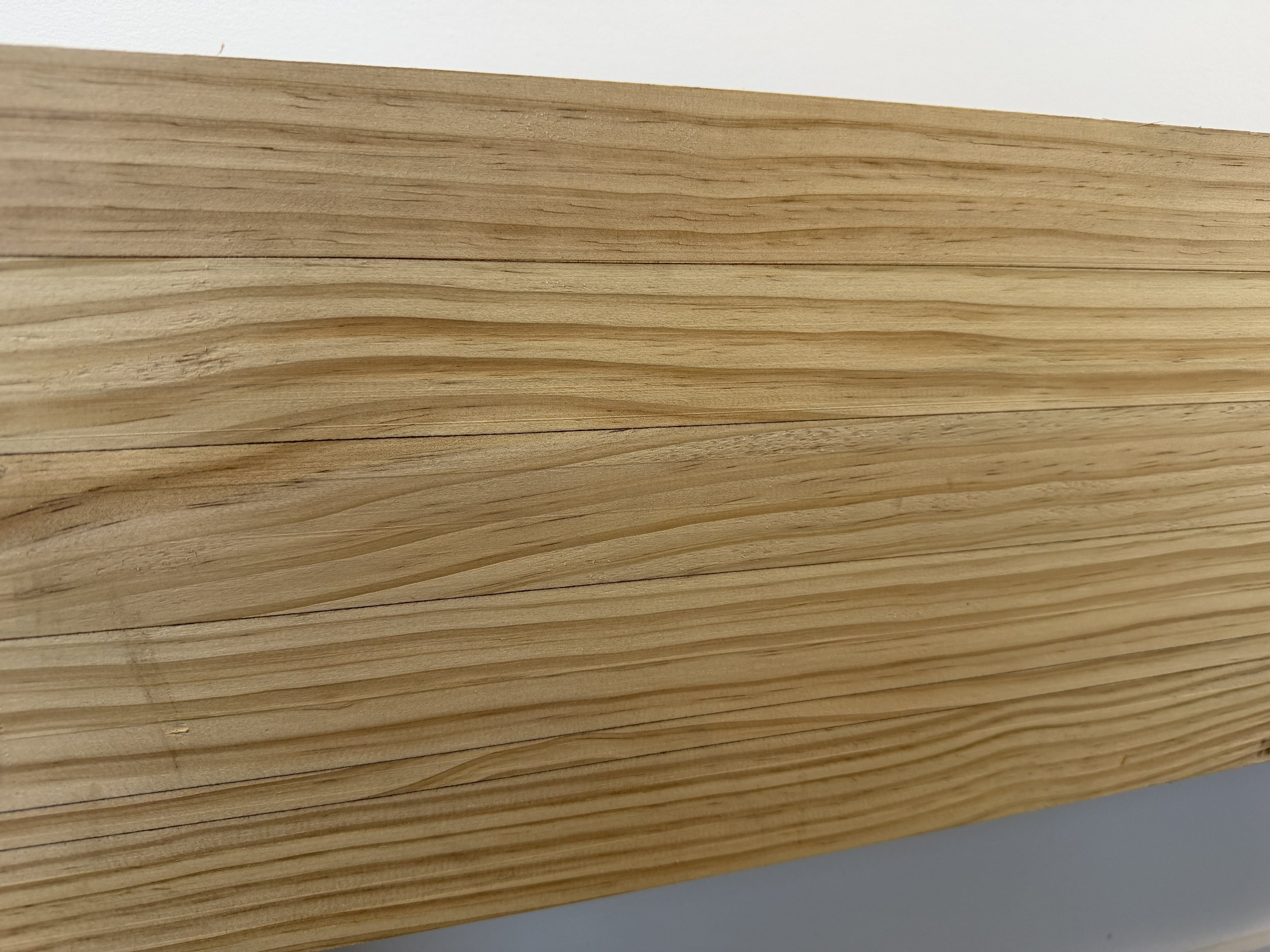 Close-up of a stack of light-colored wooden planks or boards.