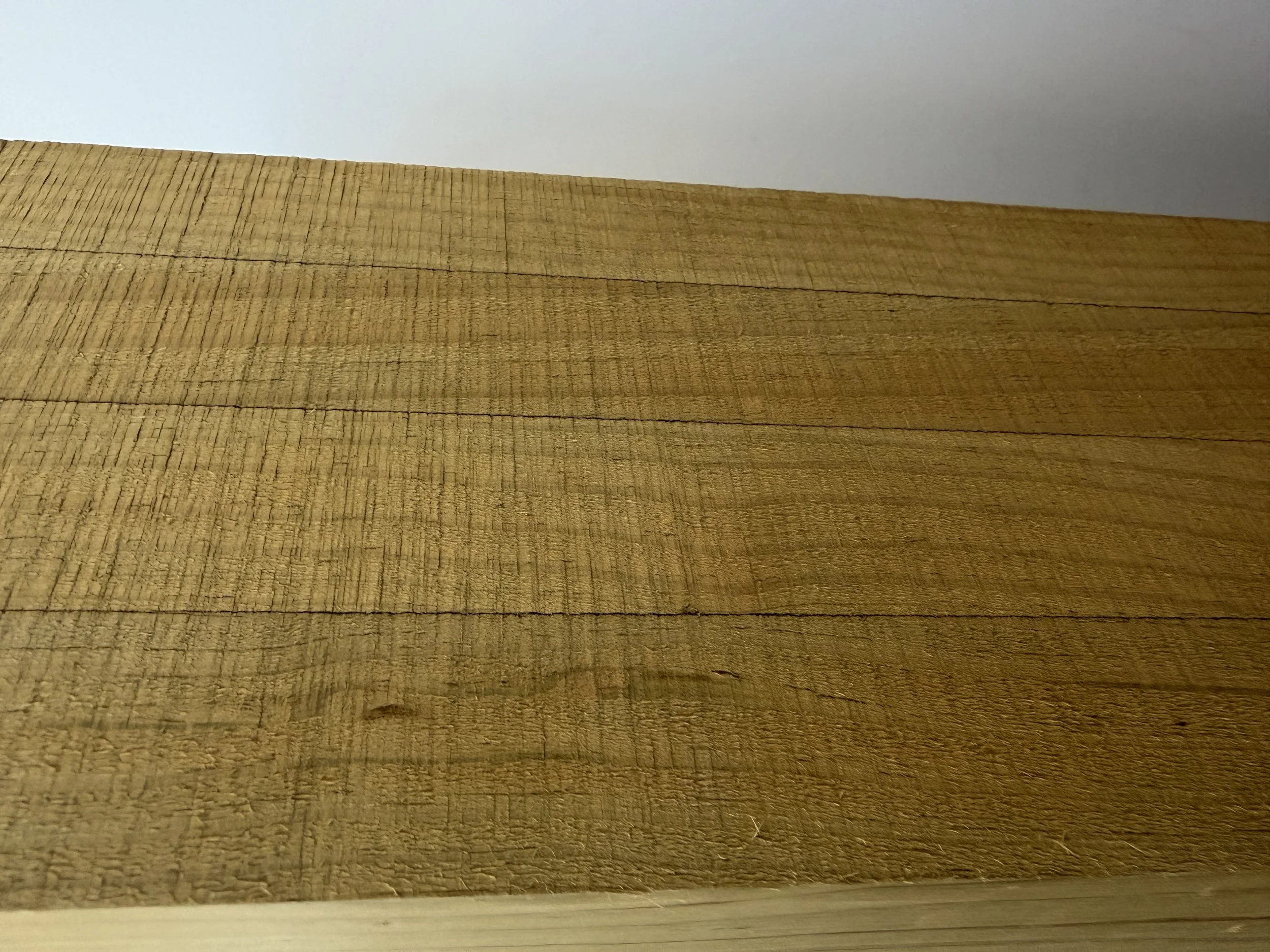 Close-up image of a wooden surface against a light blue wall.