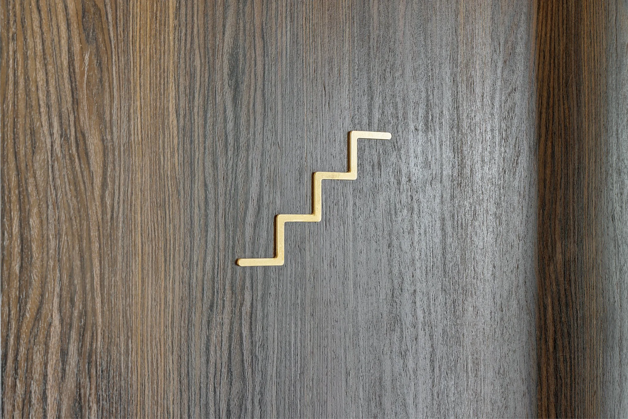 A small, light-colored staircase-shaped object on a wooden surface.