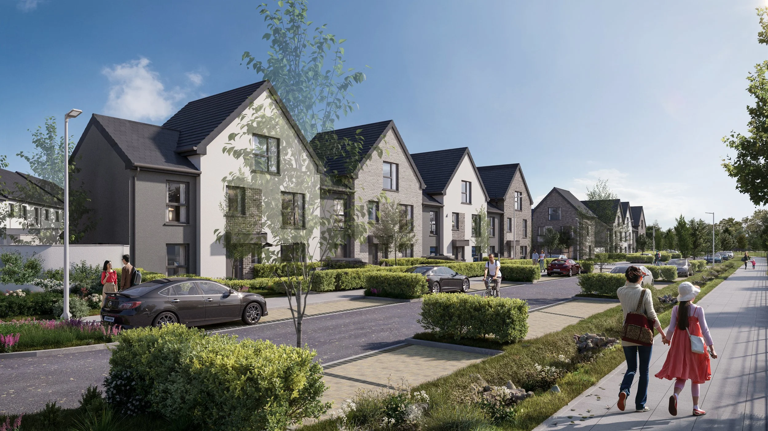 A modern residential street with row houses, cars parked alongside, and people walking and biking on the sidewalk on a sunny day.