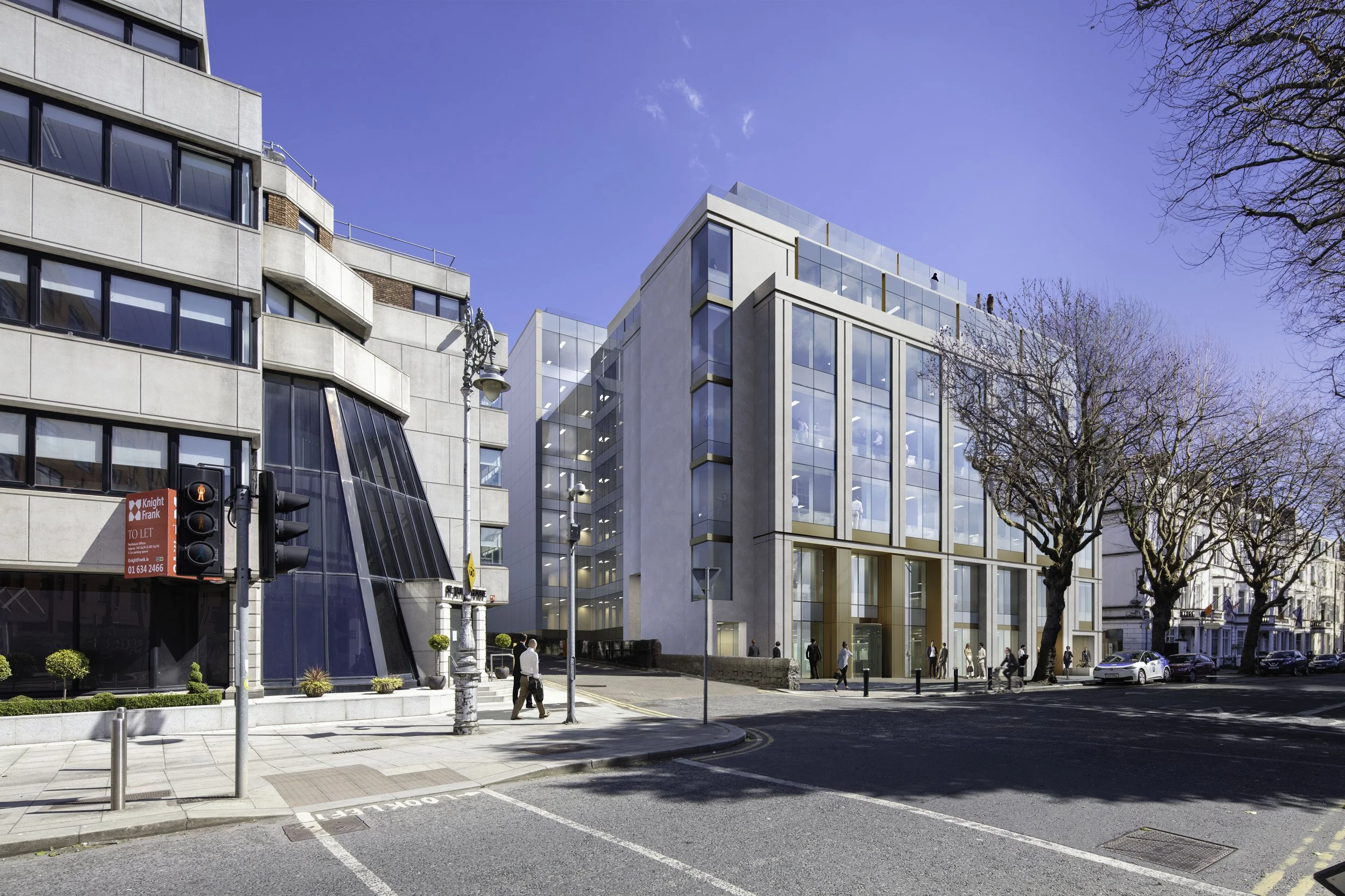 Modern multi-story office building with glass façade and people walking on the sidewalk. Clear blue sky and leafless trees in the scene.