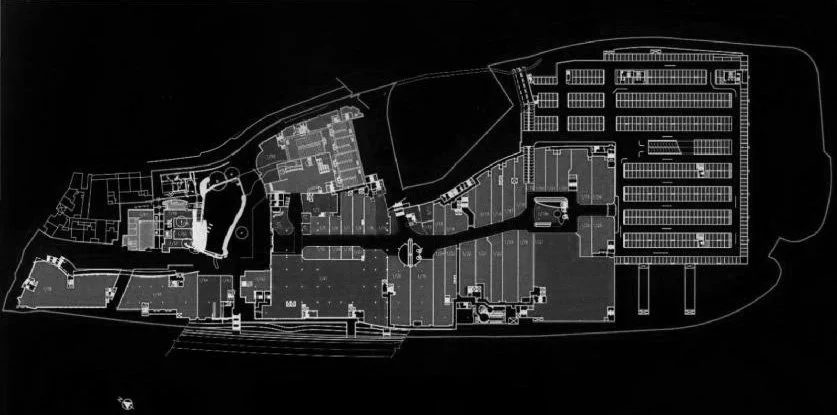 Black and white architectural floor plan of a large building or complex, showing different rooms, sections, and parking areas.