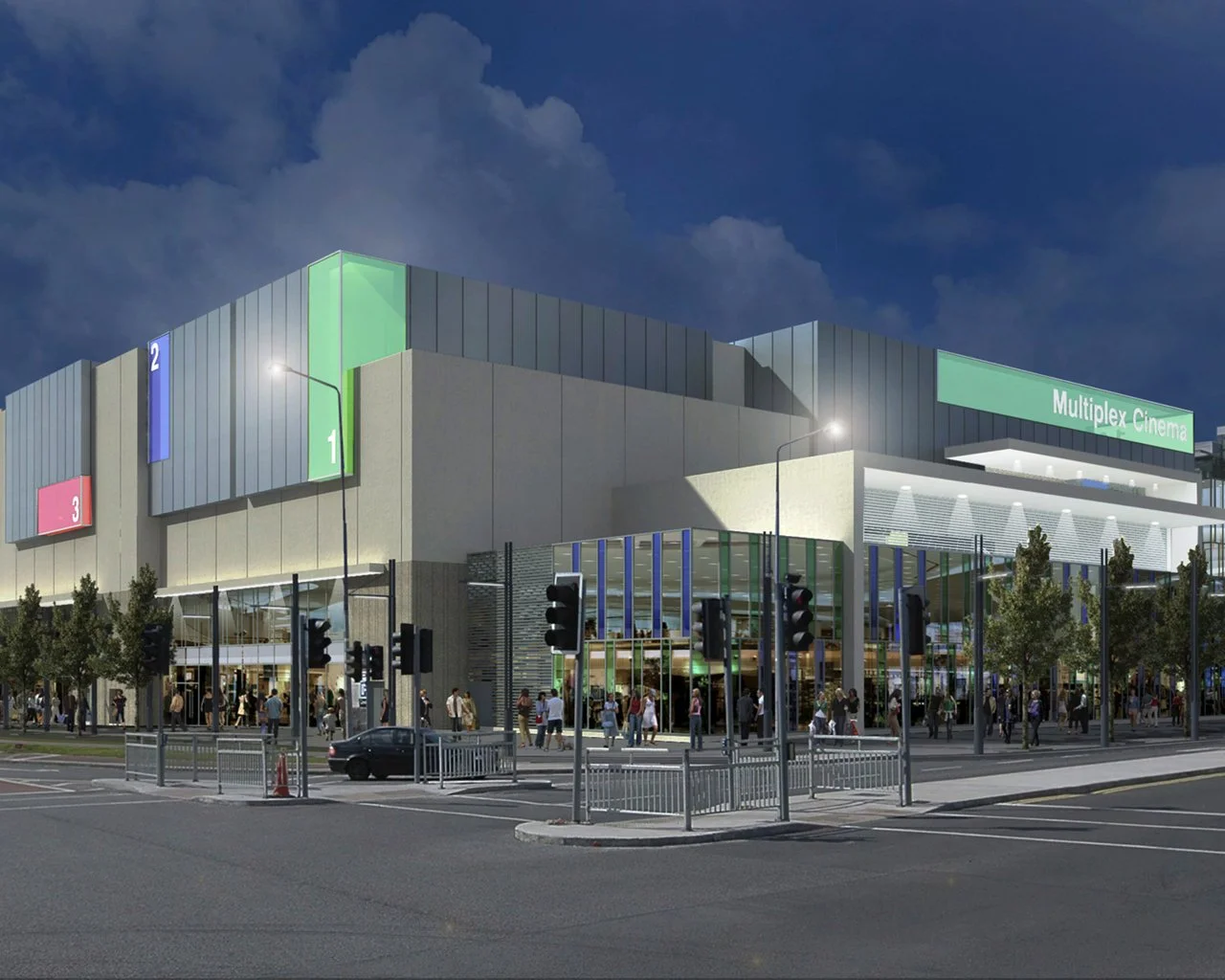 Night view of a modern multiplex cinema with colorful signage and outside crowd.
