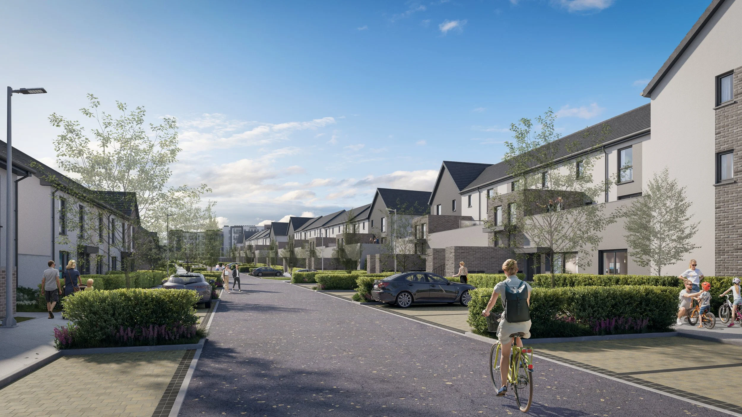A modern residential neighborhood scene with multiple people walking, cycling, and children riding bikes, lined with trees, cars parked along the street, and contemporary houses with balconies and landscaped yards under a partly cloudy sky.