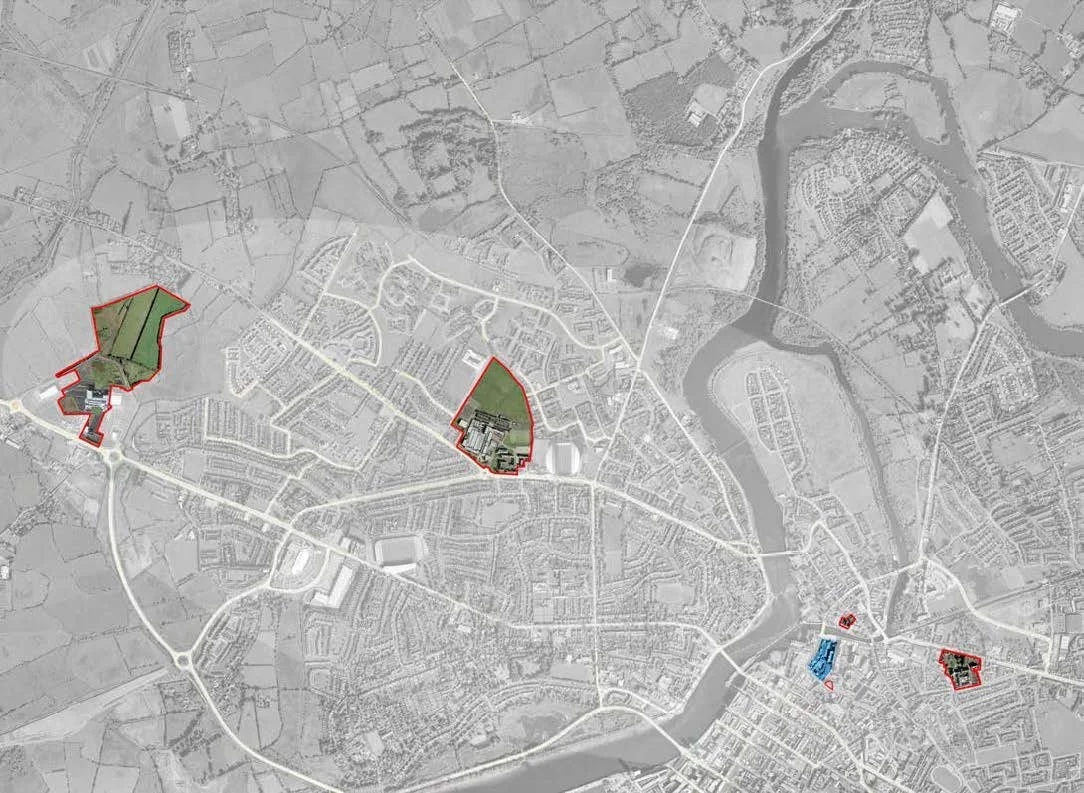 Satellite map of a city with highlighted areas outlined in red and of different colors, showing various zones and structures.