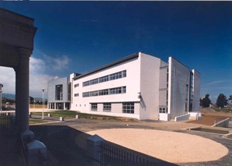 Modern white building with multiple windows and a clear blue sky