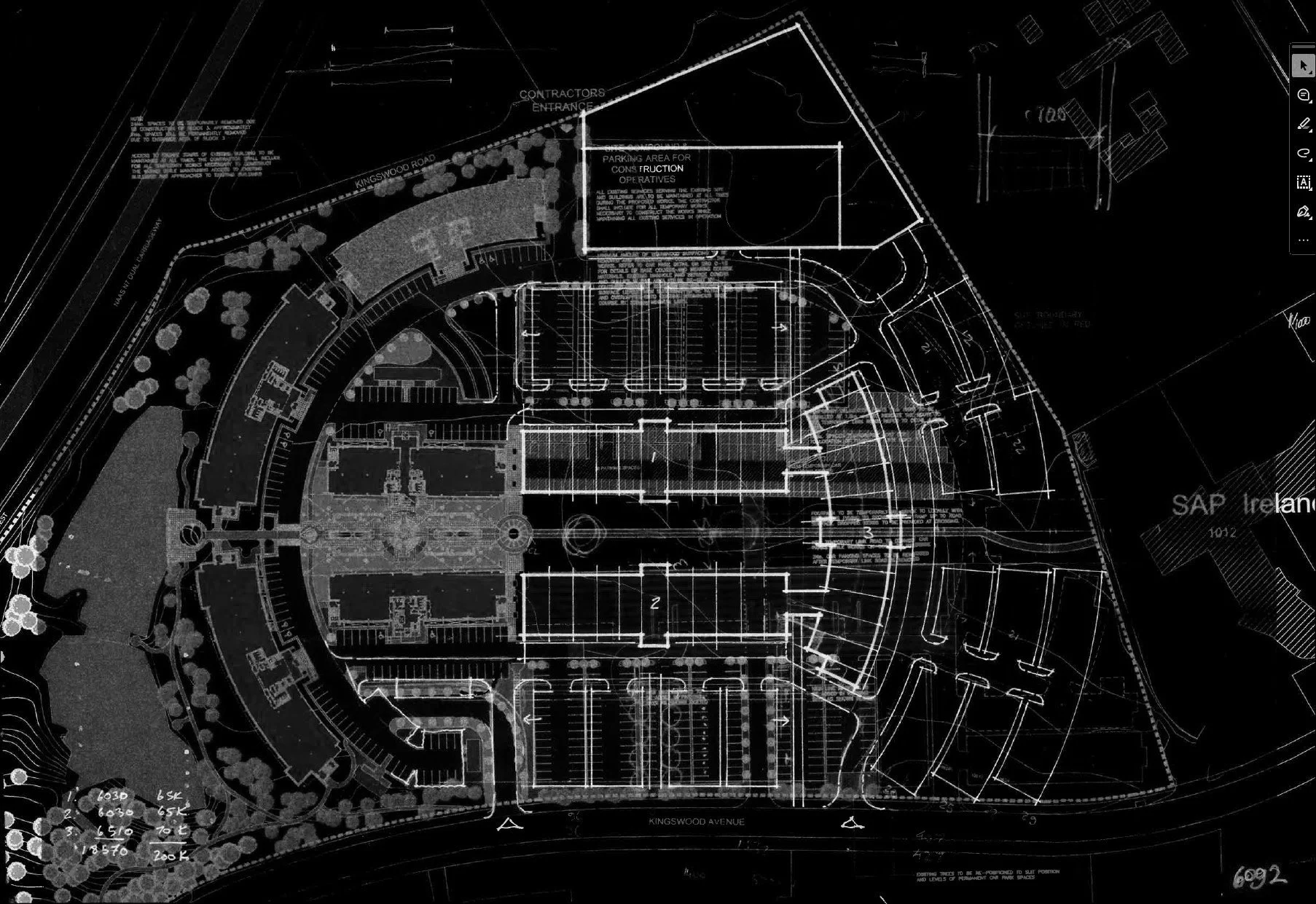 A detailed architectural blueprint showing layout plans, parking areas, roads, and landscaping for a building complex, including labeled sections for construction and utility areas.