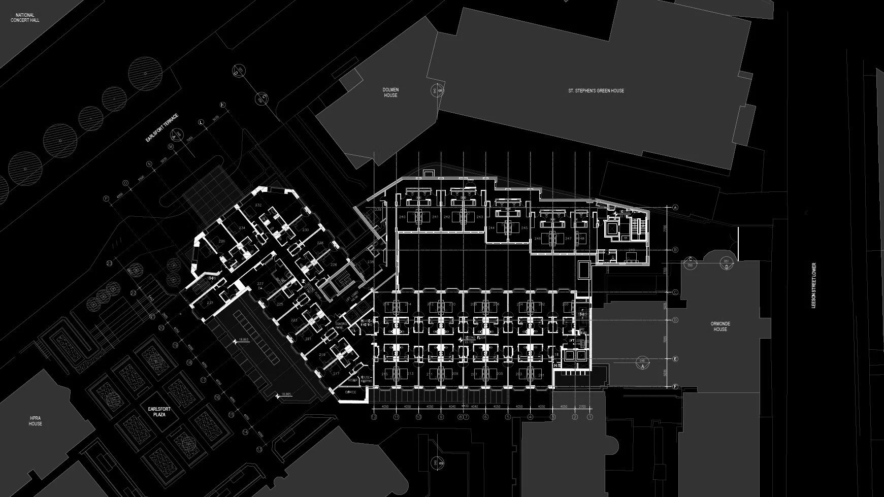 Architectural floor plan of a large building complex with multiple rooms, labeled areas, and surrounding structures, including a plaza and landscaped area.
