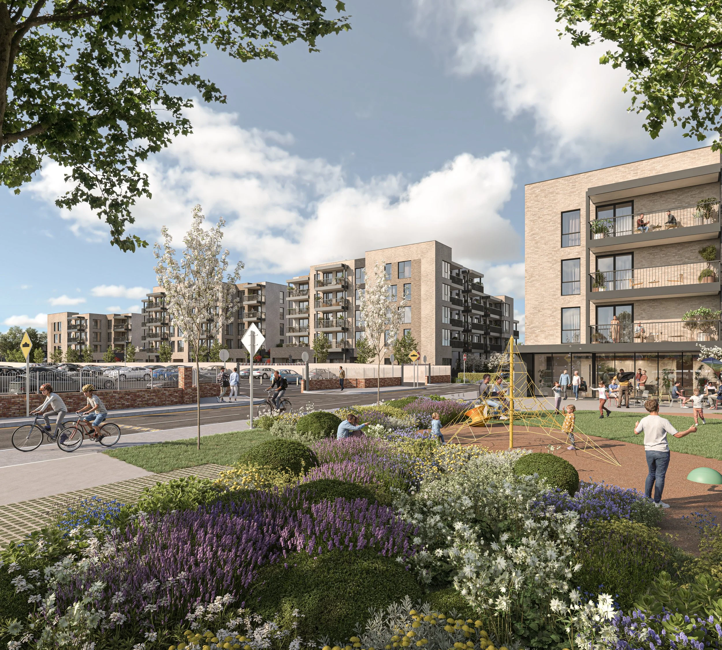A modern residential complex with multiple apartment buildings, a park with children playing, people walking and biking, and blooming flowers in the foreground under a blue sky with clouds.