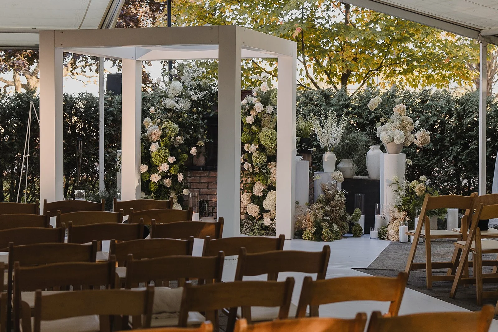 "Bold floral arch installation with vibrant flowers for a luxury outdoor wedding by a Toronto florist"