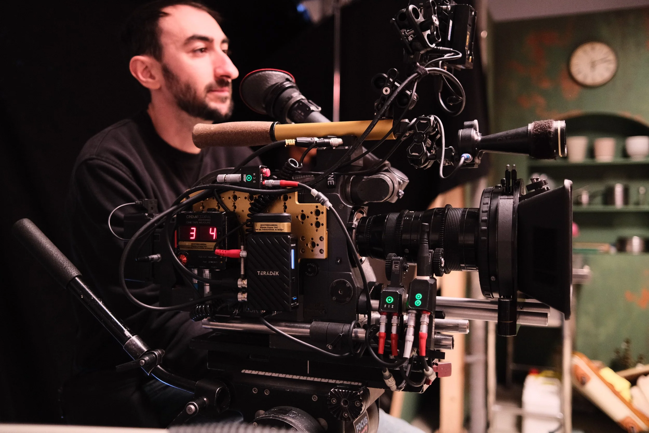 A man operating a professional film camera on a film set or studio.