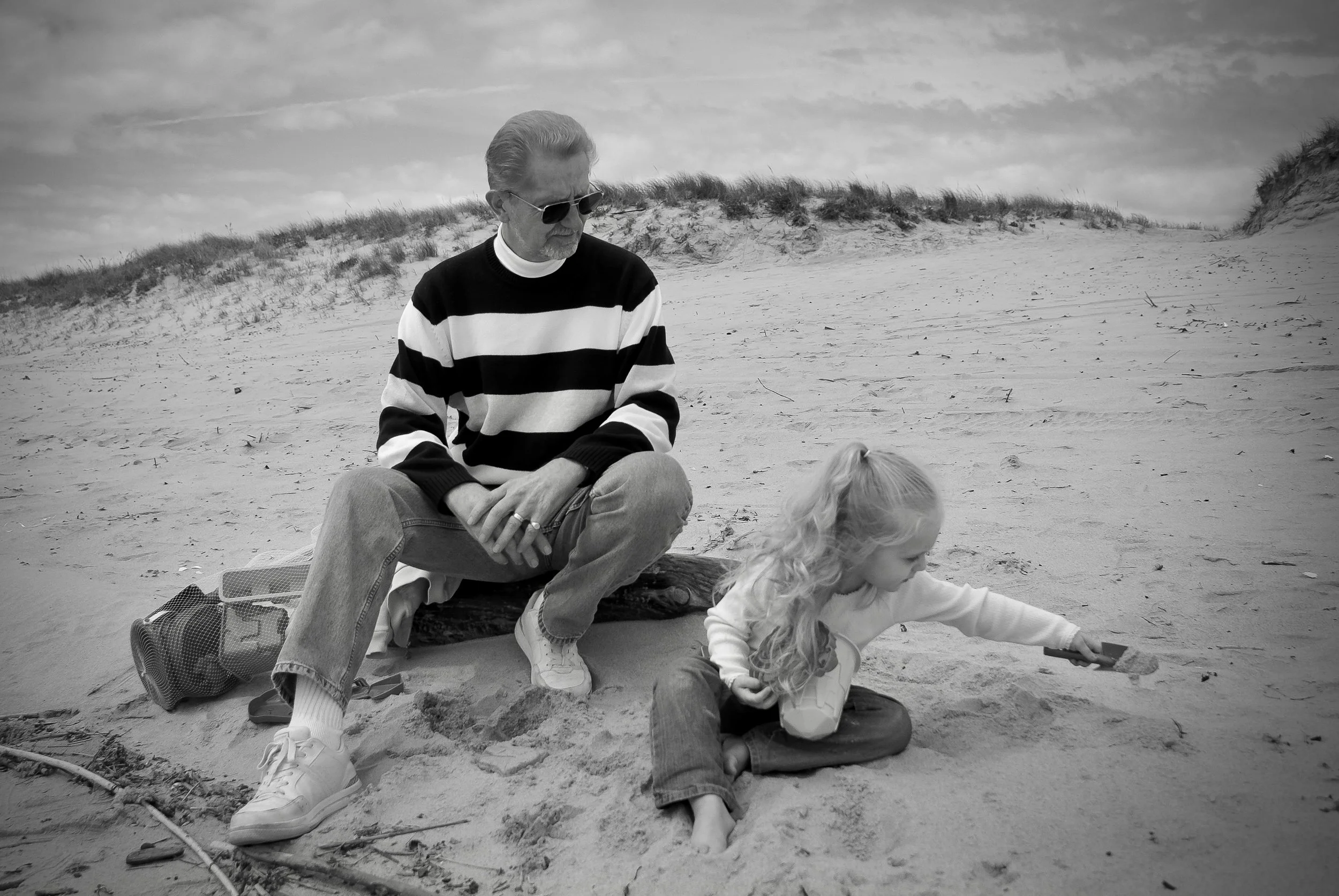 Candid photo of a grandfather and granddaughter together on the beach, a preserved family memory