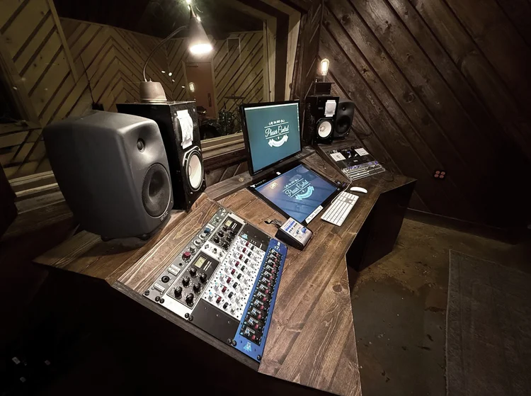 The desk from the left, outboard racks and near-field monitors in view.