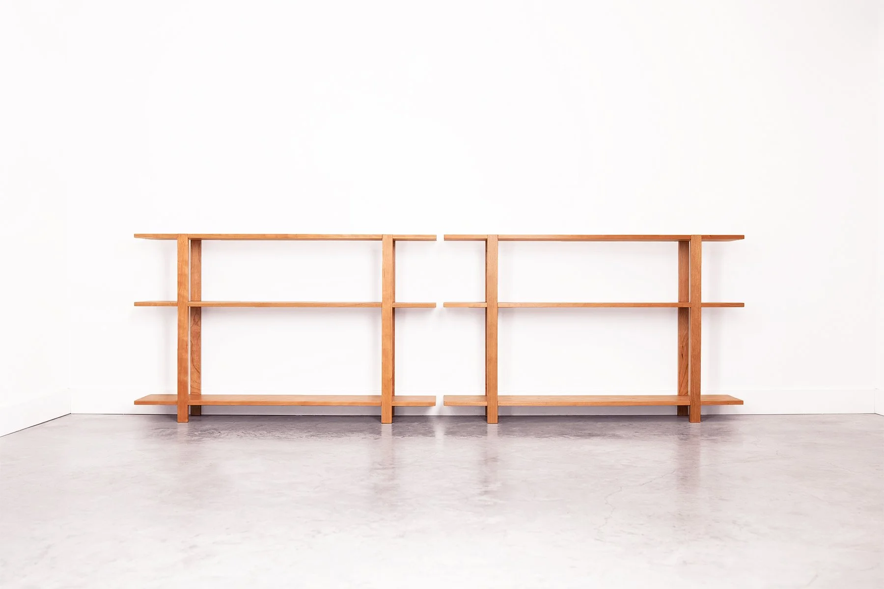 A pair of solid black cherry wood book shelves with three levels, handmade in Nelson BC Canada.