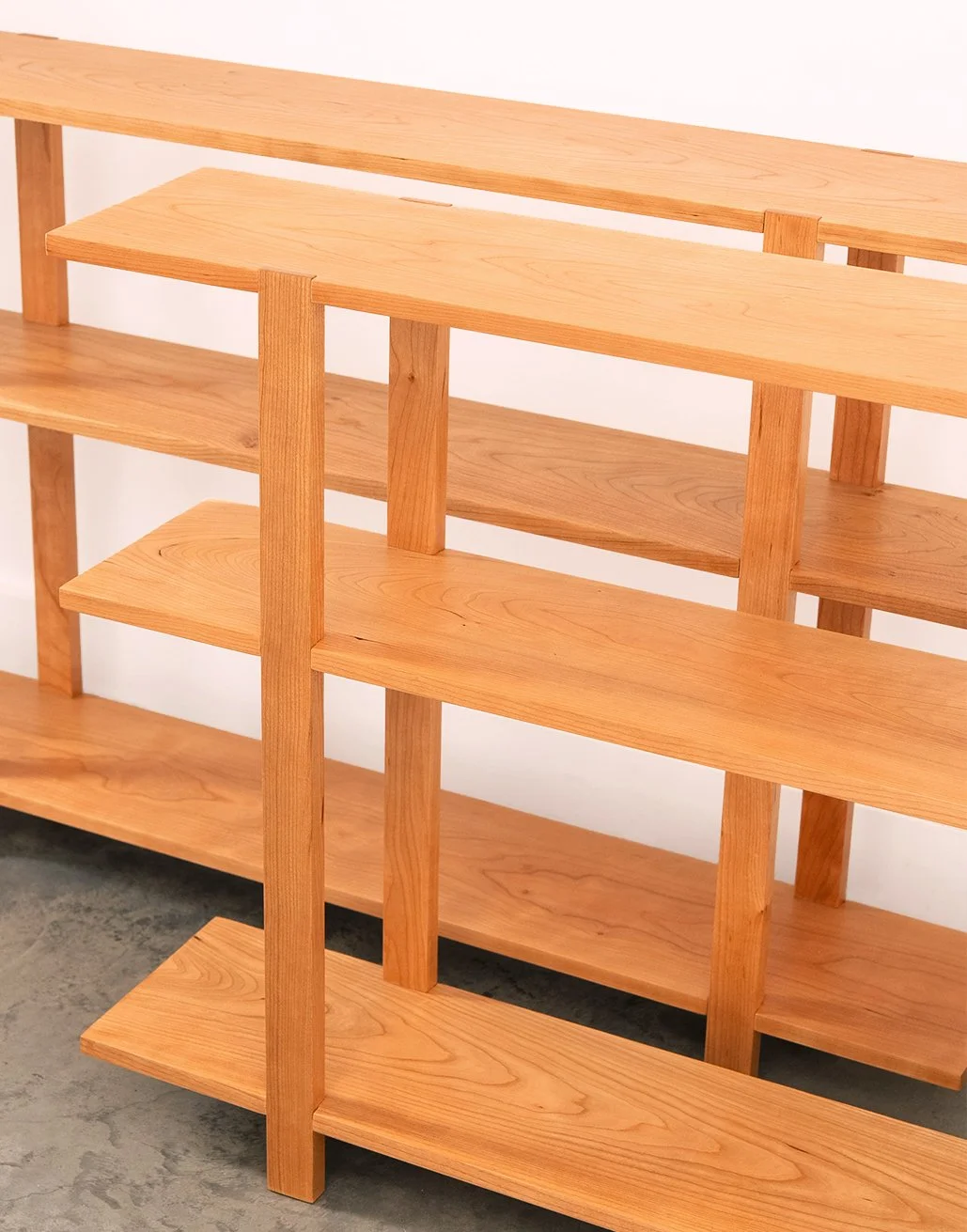 A pair of solid black cherry wood book shelves with three levels, handmade in Nelson BC Canada.