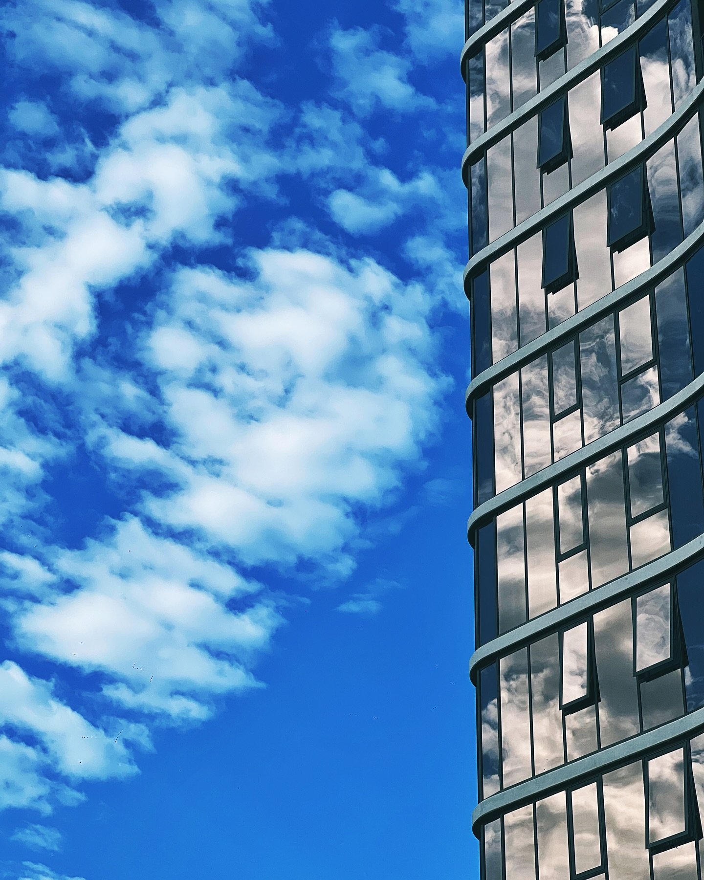 Curves of glass hugging the sky.
The reflection becomes part of the structure &mdash; like the sky lives inside.

#JustLuis #BrisbaneArchitecture #UrbanReflections #ModernCurves #SkylineDesign #GlassFacade #ArchitecturePhotography #SoftClouds #CityAn