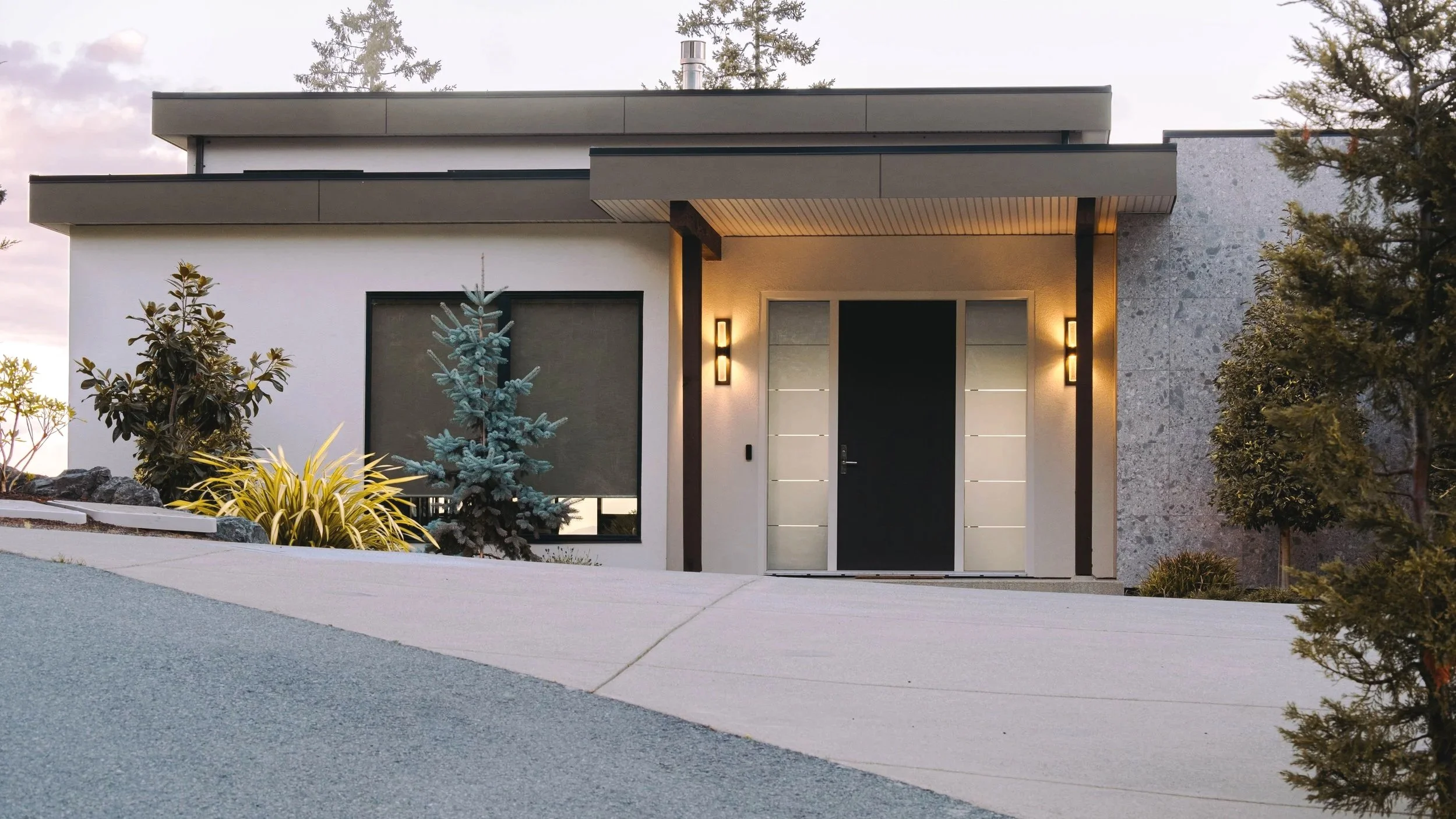 Modern house with a light stucco exterior at dusk