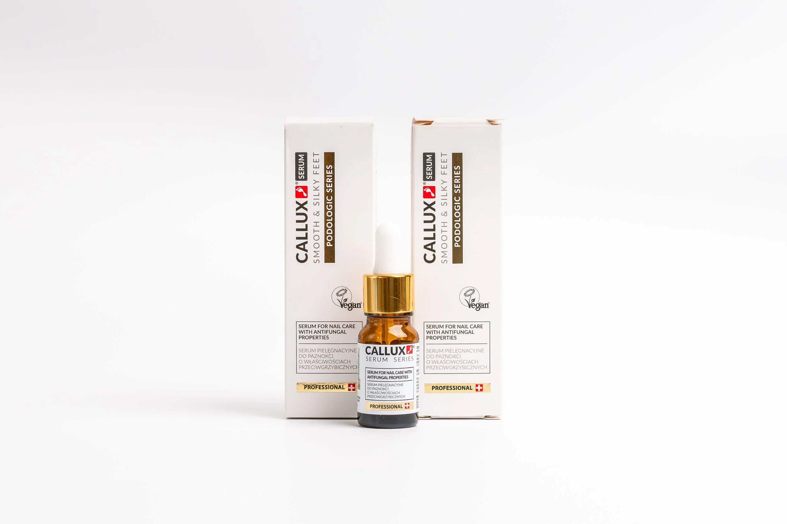 Callux Nail Serum in a small amber bottle with a white dropper, placed in front of its packaging boxes, white background.