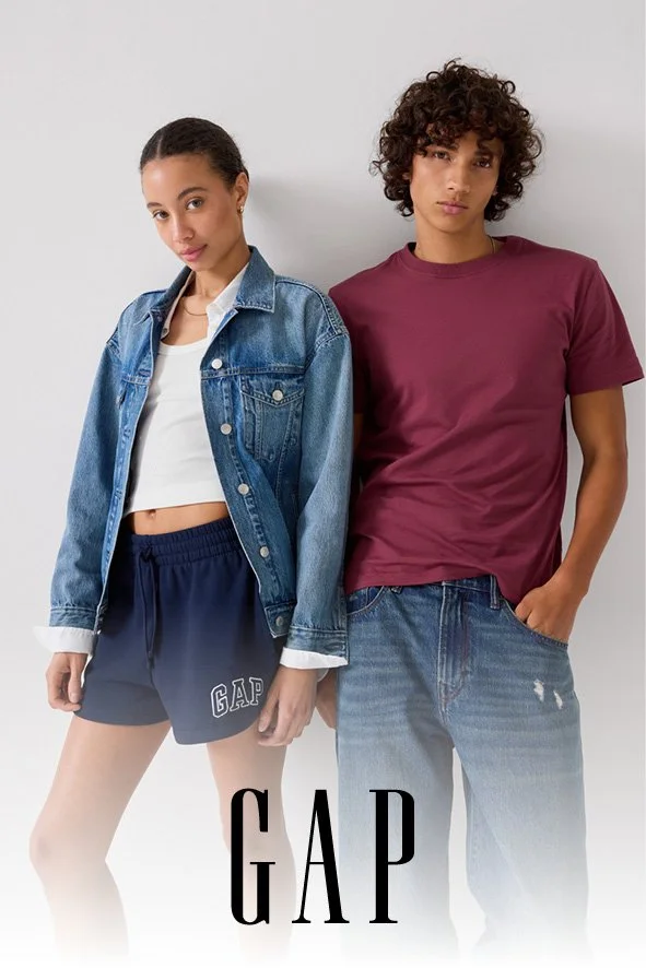 Zwei junge Menschen in lässiger Kleidung, ein Mädchen in Jeansjacke und Shorts, ein Junge in T-Shirt und Jeans, vor weißem Hintergrund, mit GAP-Logo