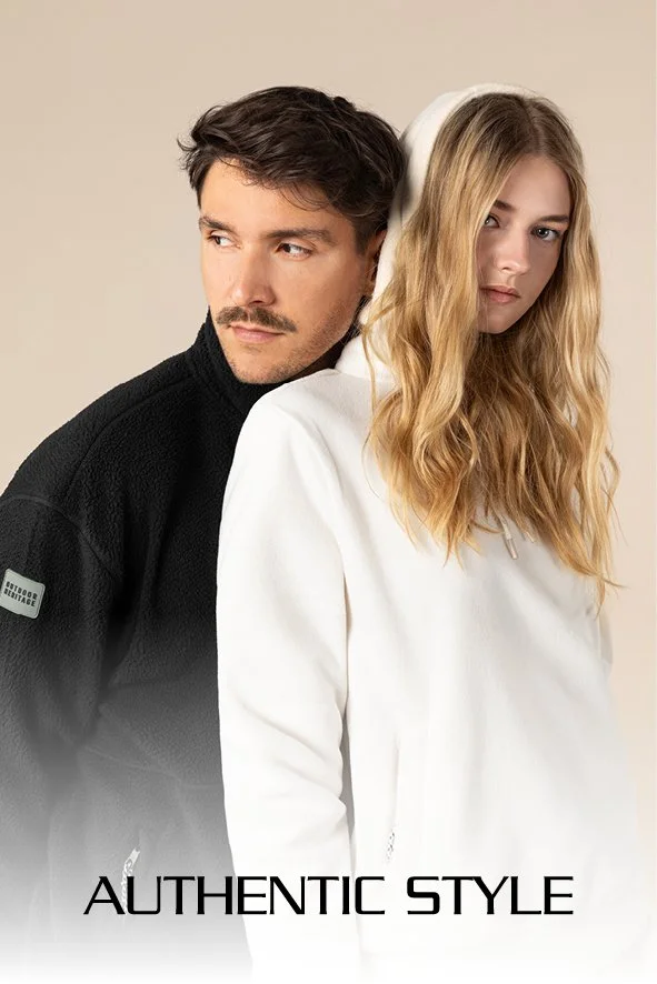 Ein Mann und eine Frau stehen Rücken an Rücken, der Mann schaut zur Seite, die Frau trägt einen weißen Hoodie, der Hintergrund ist neutral. Text: 'Authentic Style'.
