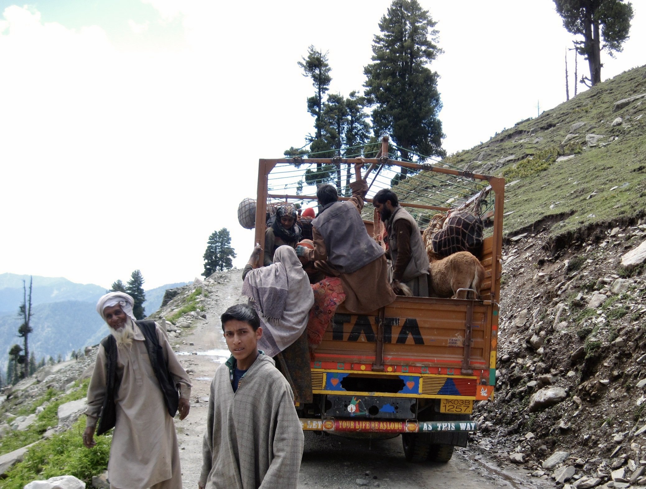 People loading livestock, belongings and themselves onto a truck while crossing Margan Top.