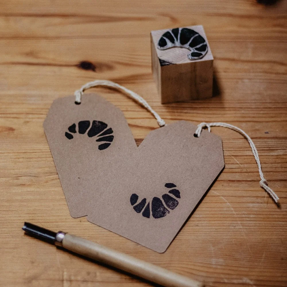 fertig bedruckte Anhänger mit benutztem Stempel. Motiv: ein Croissant