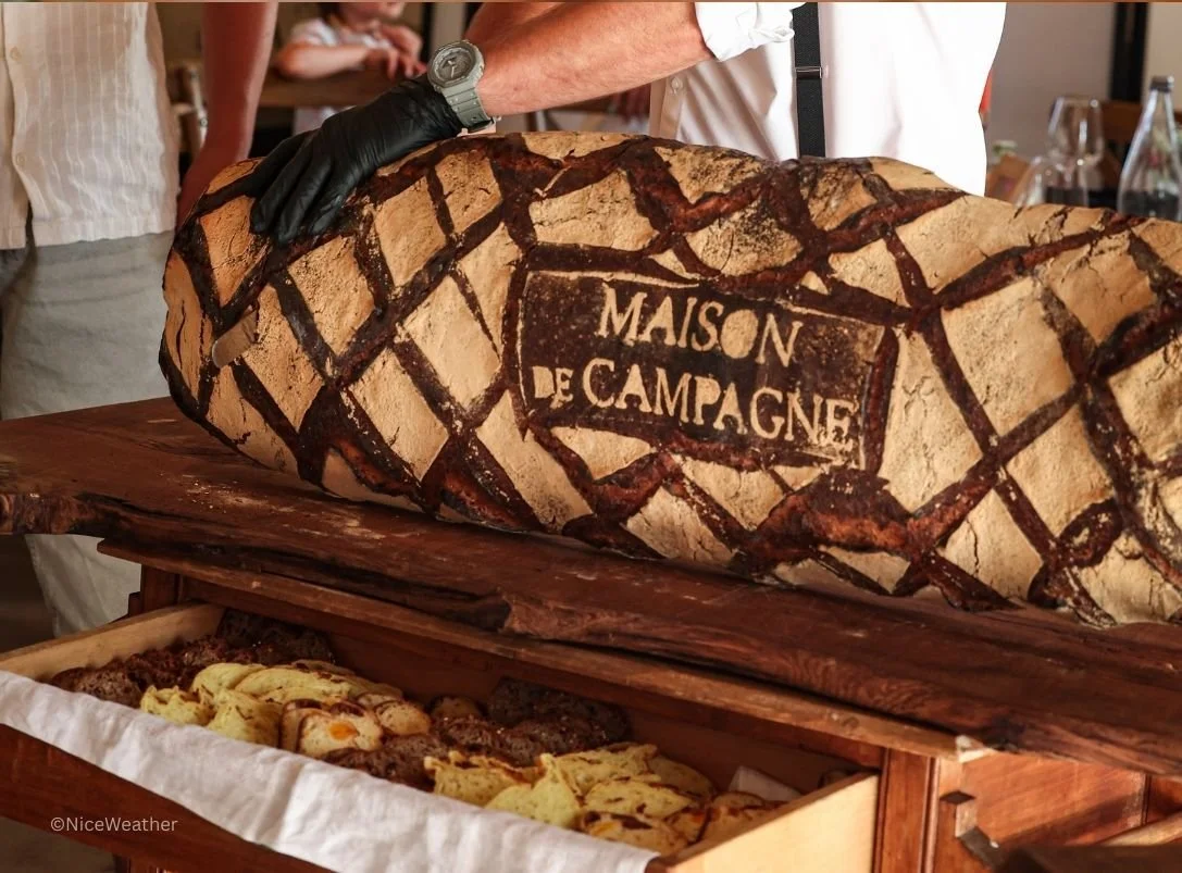 Découpe de miche de pain locale devant convives