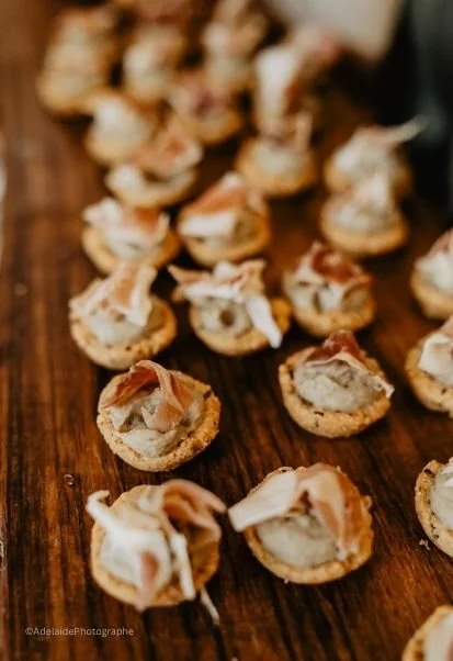 Tartelettes apéritives avec du jambon, œuf et mayonnaise sur une planche en bois.