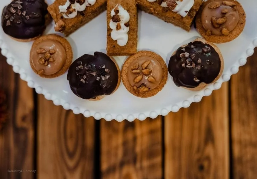 Assortiment de biscuits et de petits gâteaux sur une assiette blanche, servant à décorer ou à servir avec du thé ou du café.