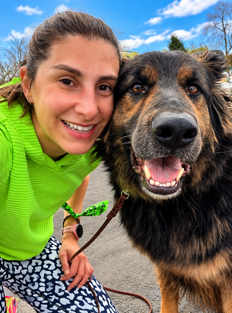 Run coach Jamie Davenport outdoors with her German shepherd running companion.