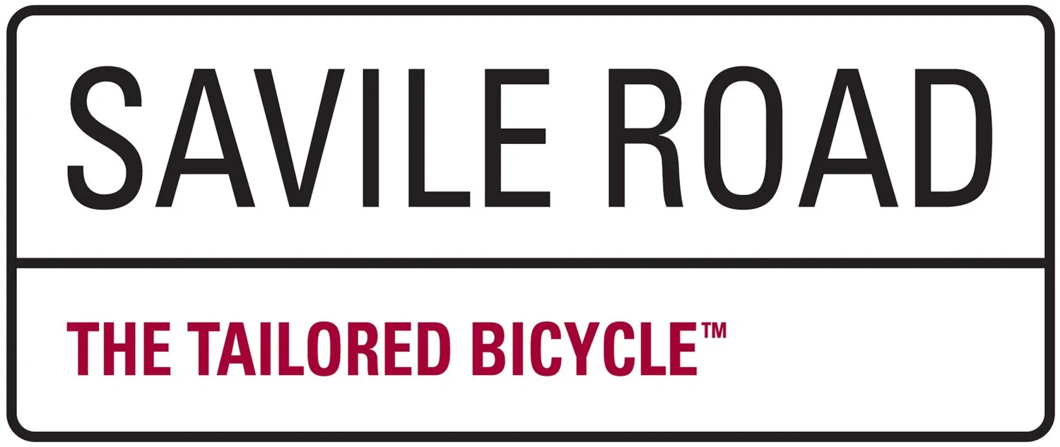 A logo that looks like a street sign with the words 'SAVILE ROAD' on the top and 'THE TAILORED BICYCLE' on the bottom.