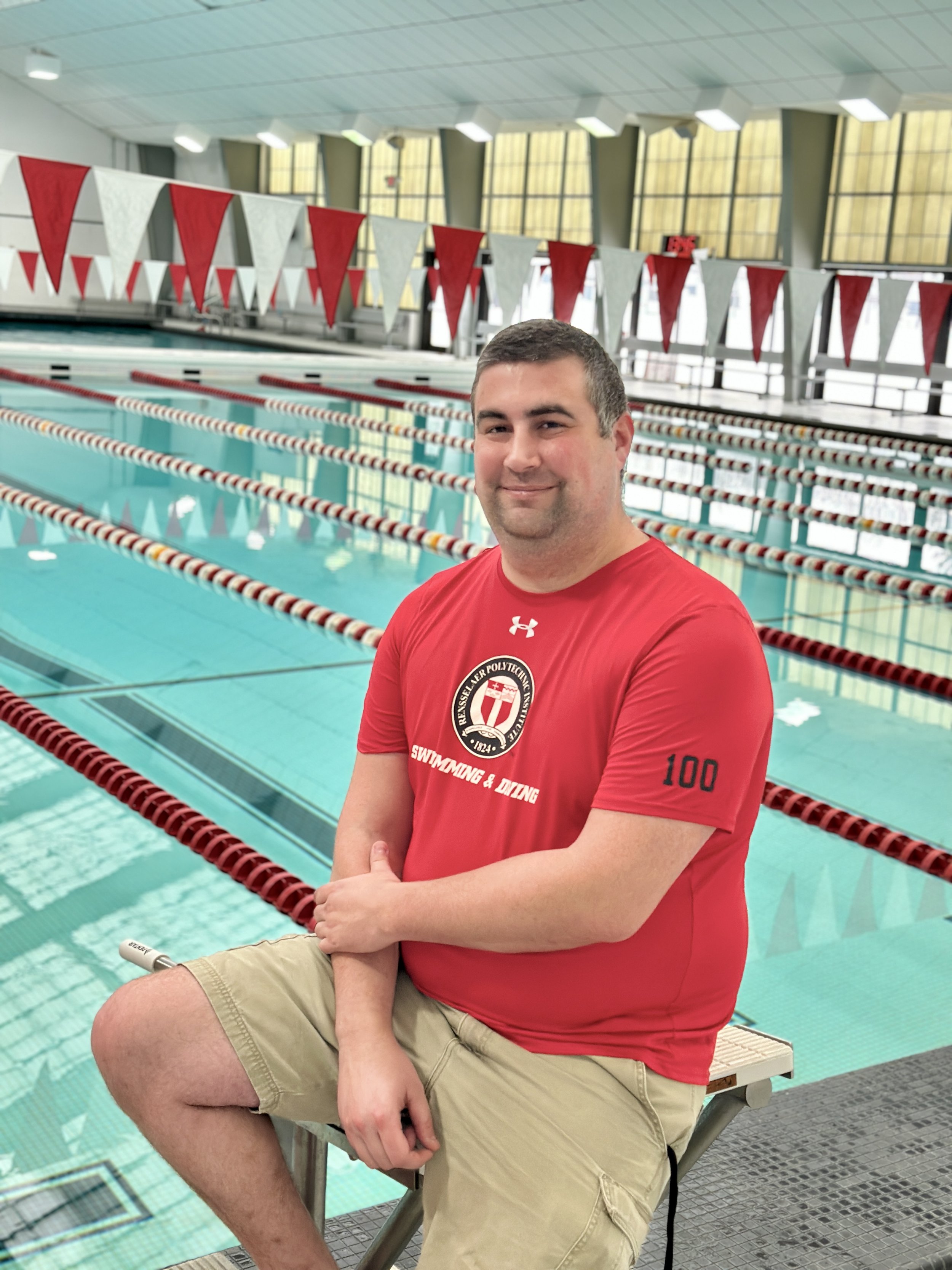 Swim Coach Mike smiling in front of the pool