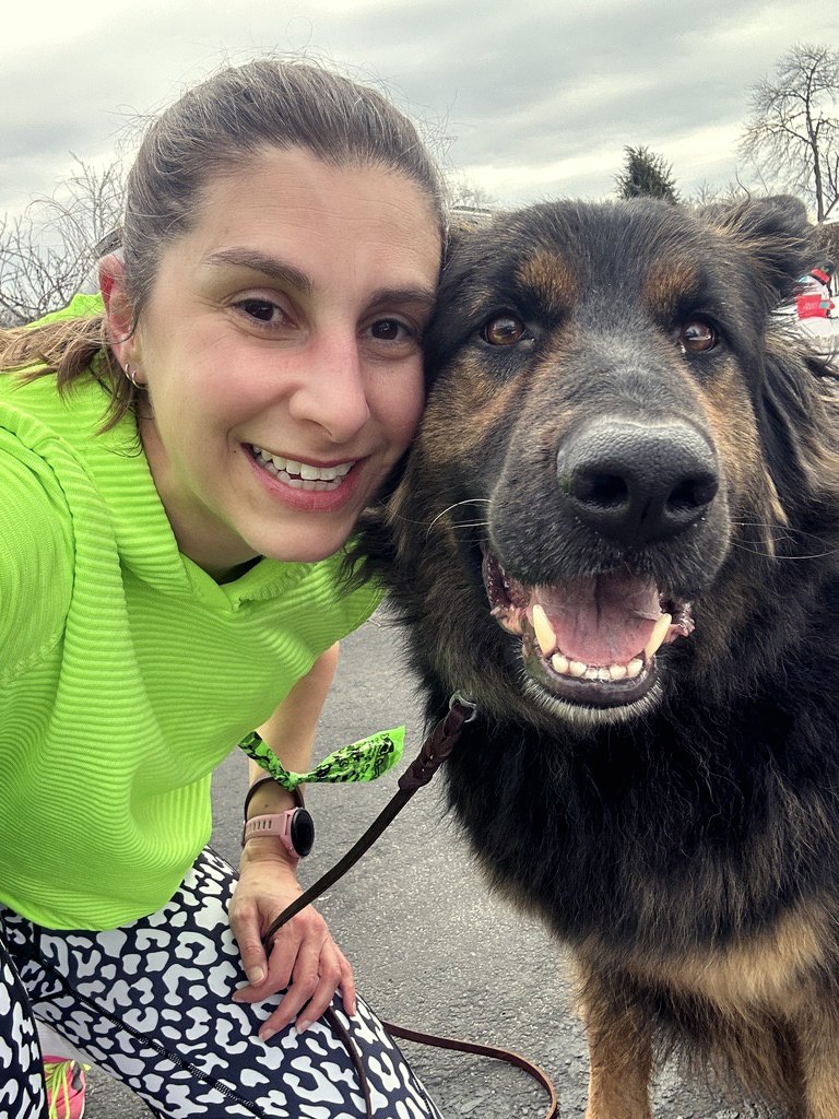 coach jamie posing for a selfie with her fluffy German shepherd running partner.