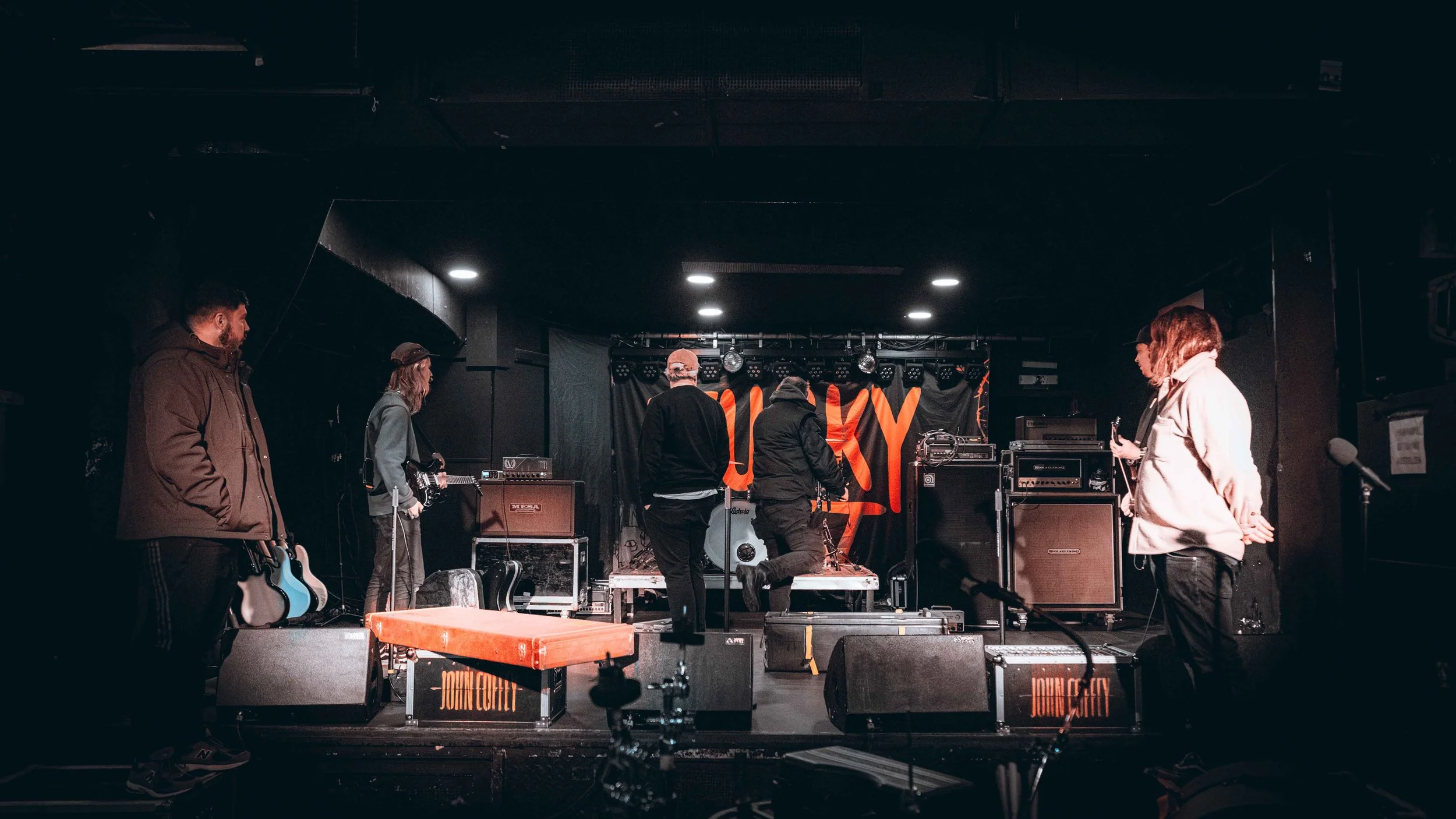 People setting up musical equipment on a stage with a 