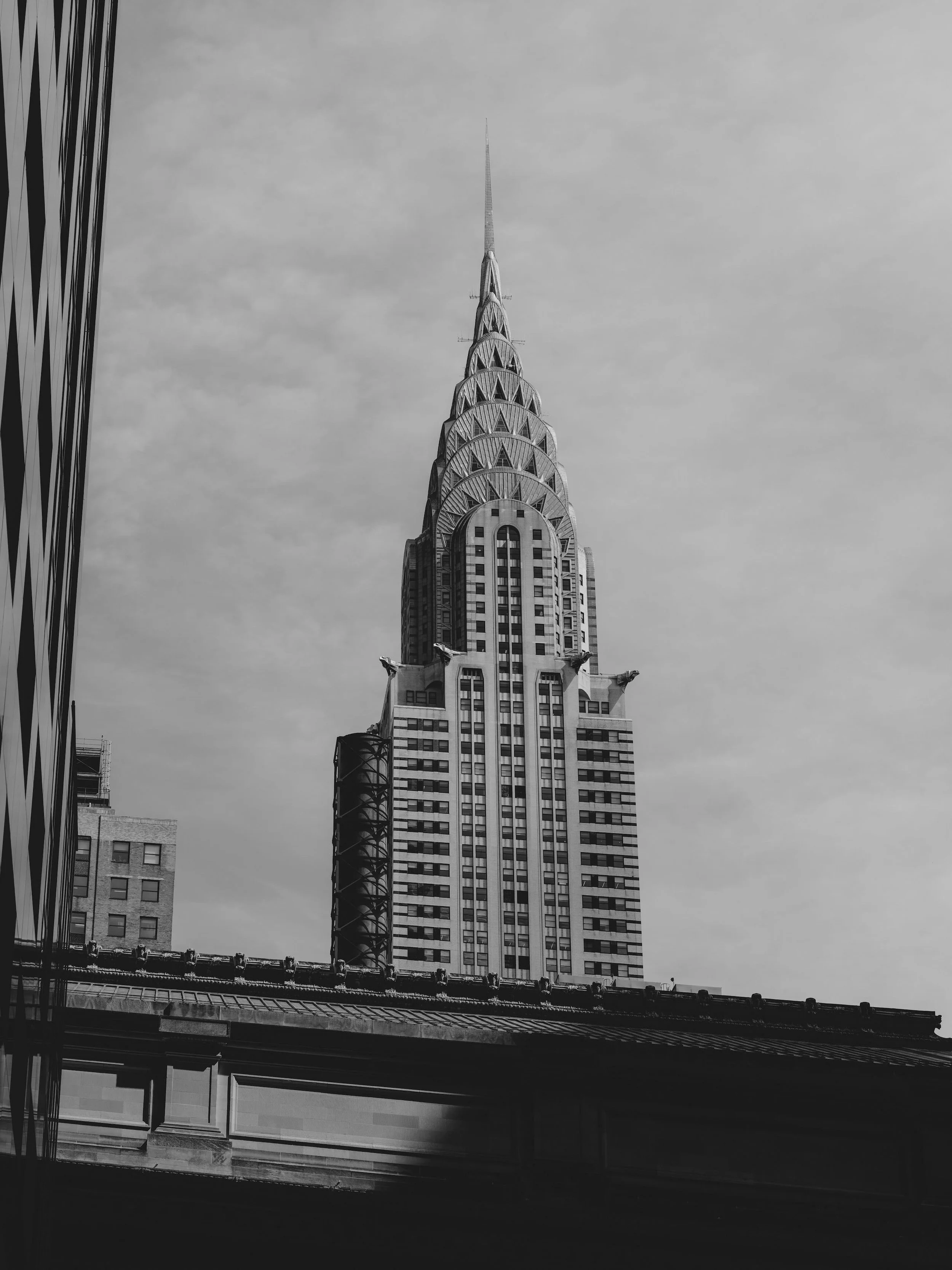 Le gratte-ciel emblématique de New York, connu sous le nom de l'Empire State Building, vu en noir et blanc depuis la rue.