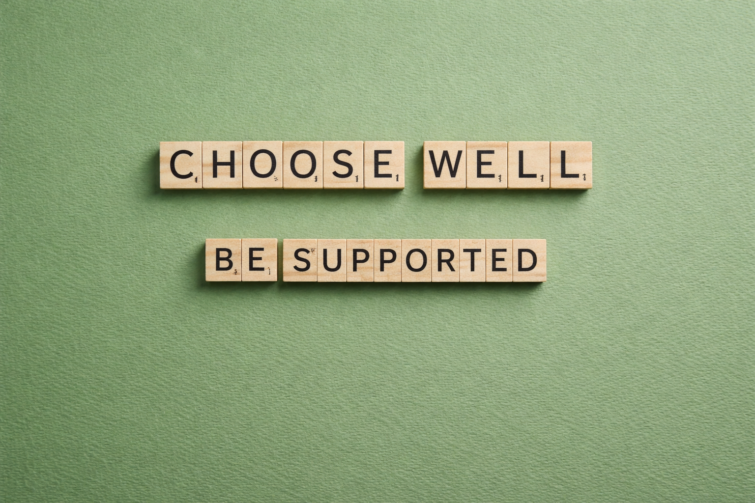 Scrabble-Buchstaben auf grünem Hintergrund mit den Worten „Choose well“ und „Be supported“ – Symbol für individuelle Hypnose und Begleitung