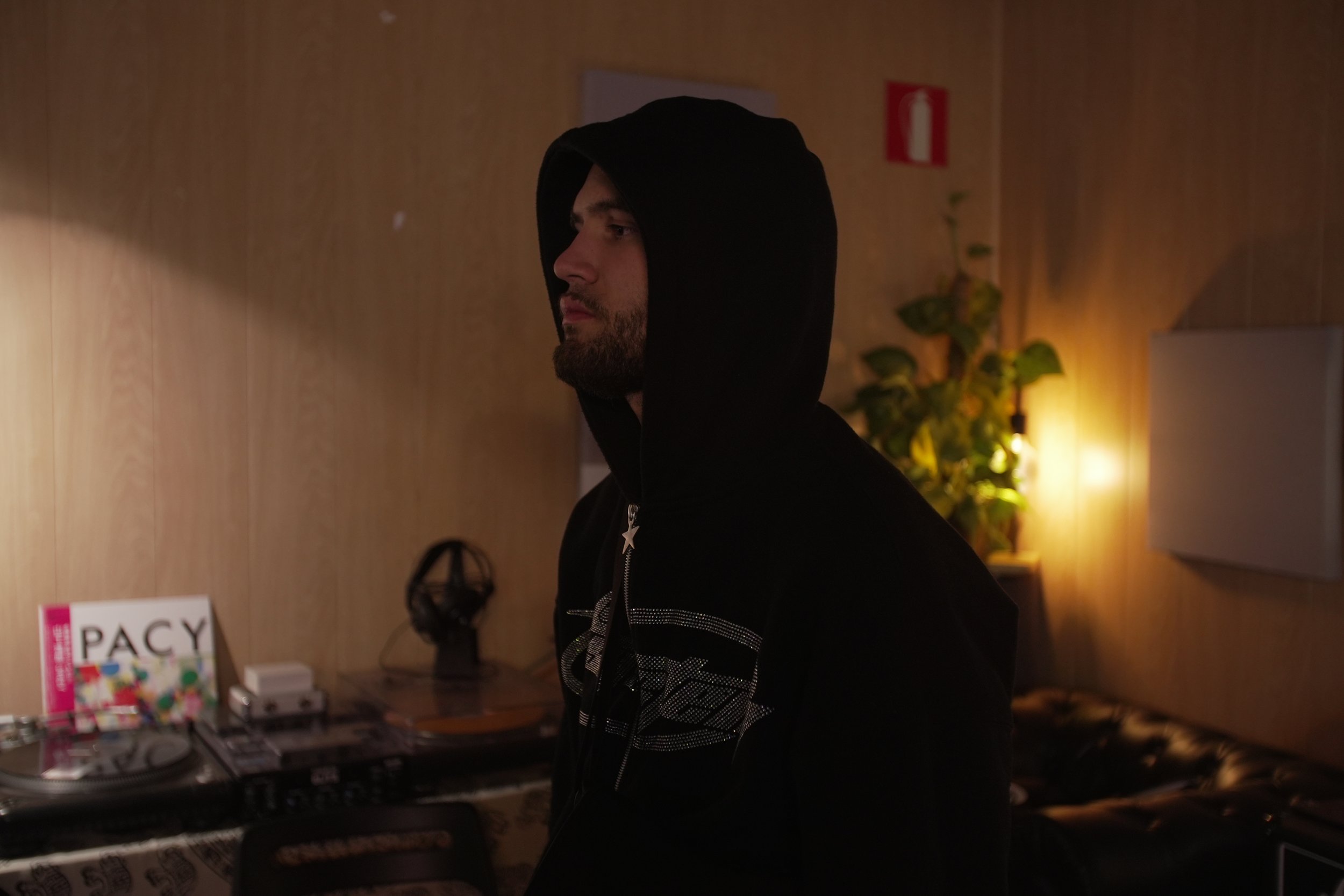 Hombre con gorro con capucha en una habitación oscura con luz cálida