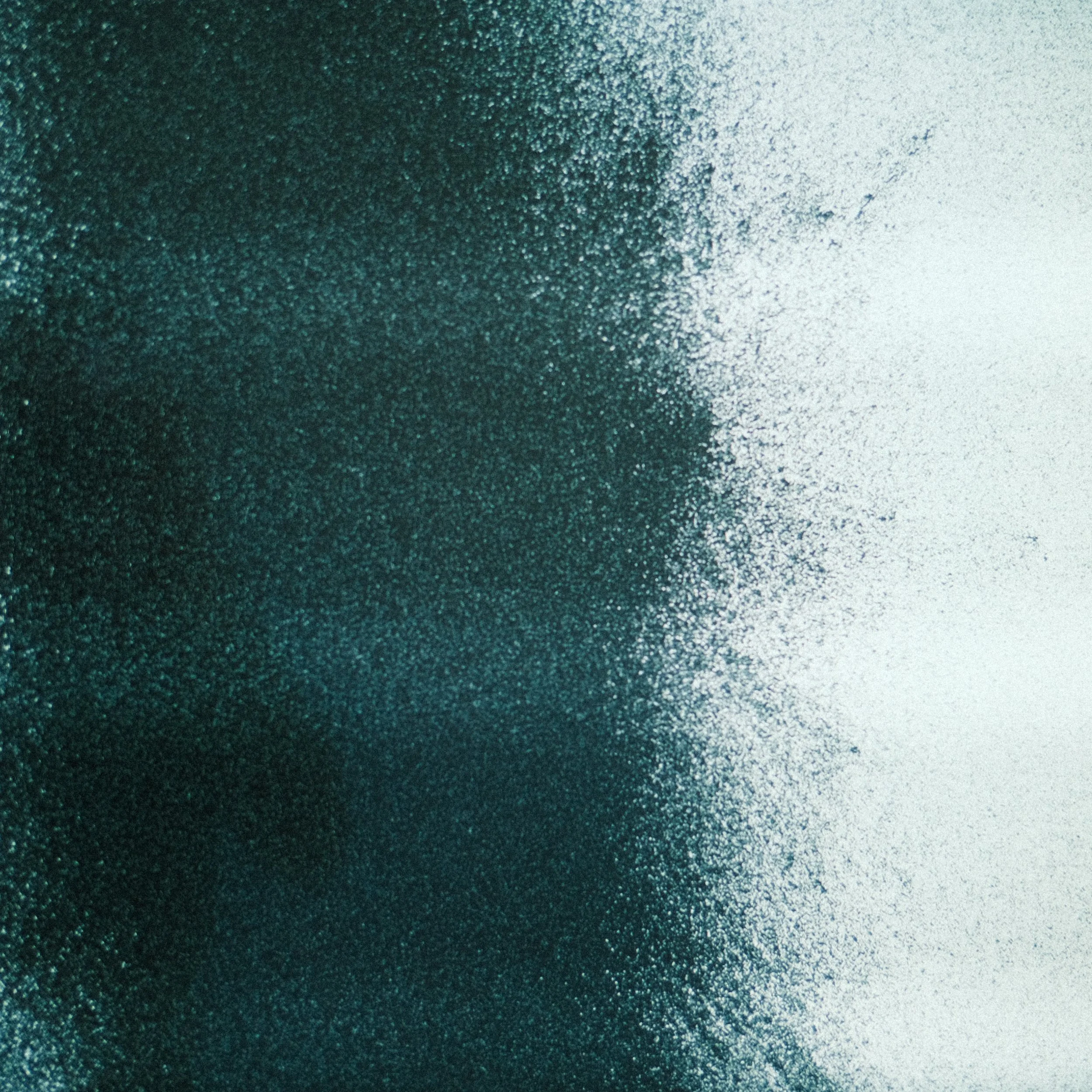 Imagem abstrata com efeito de spray ou poeira, com tons de azul escuro para o lado esquerdo e branco para o lado direito.