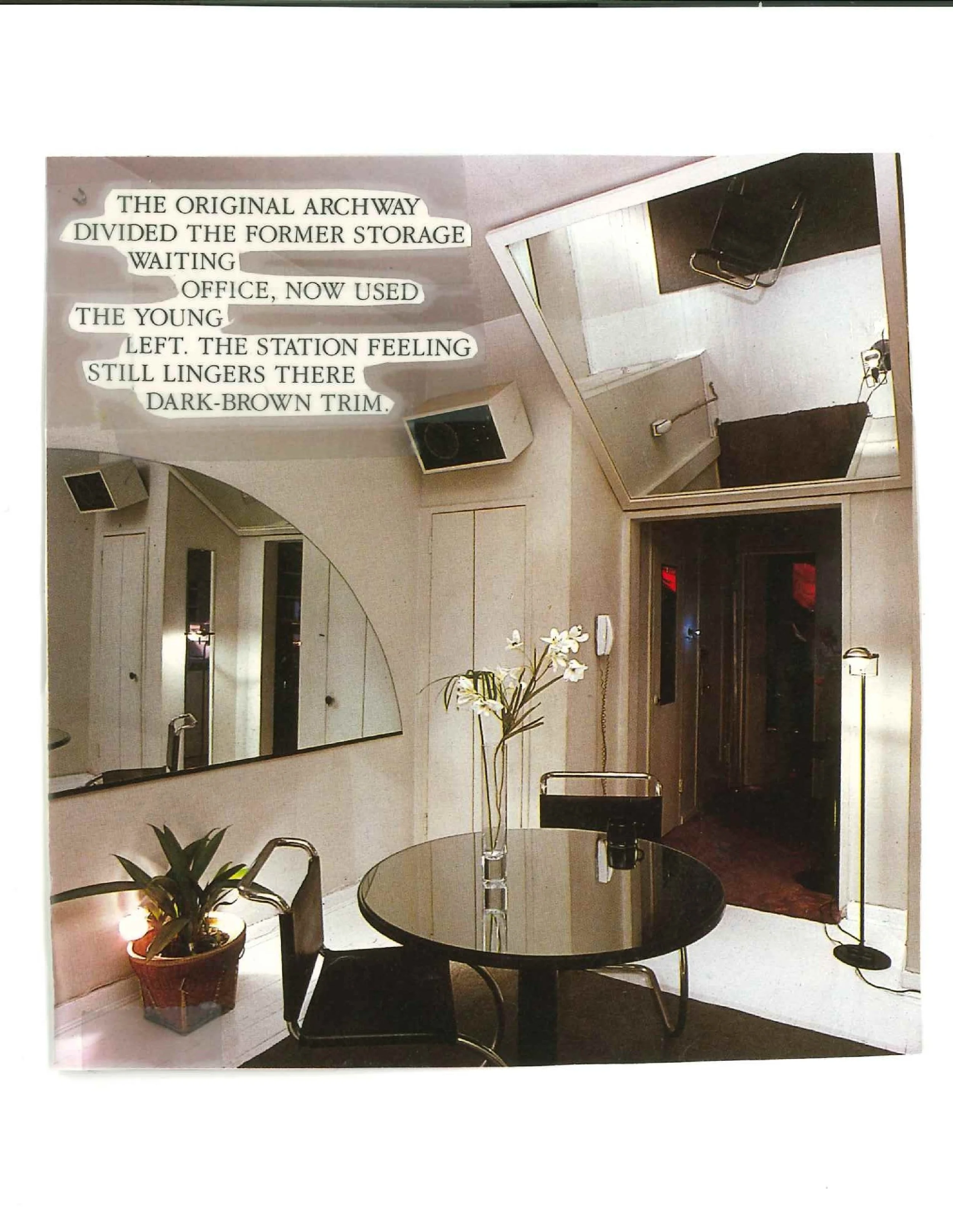 Modern office interior with round glass table, black chairs, mirrored wall, plant, overhead lighting, and a poem on the wall.