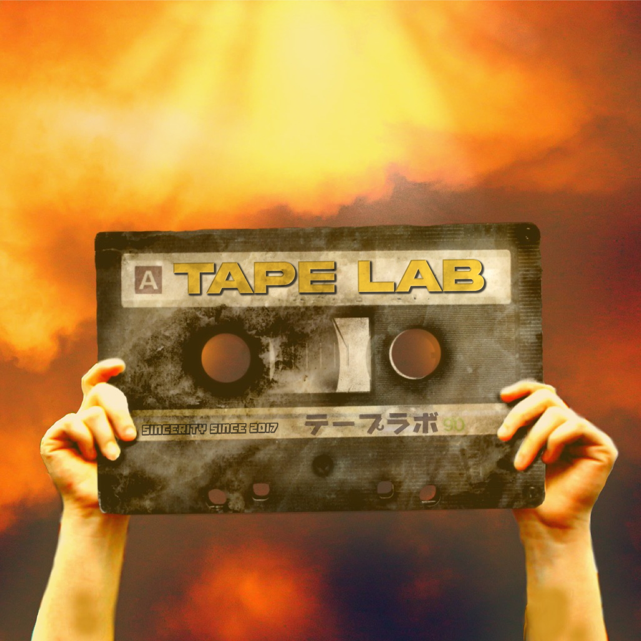 Two Hands hold a cassette tape that reads "TAPE LAB" in the air, orange background