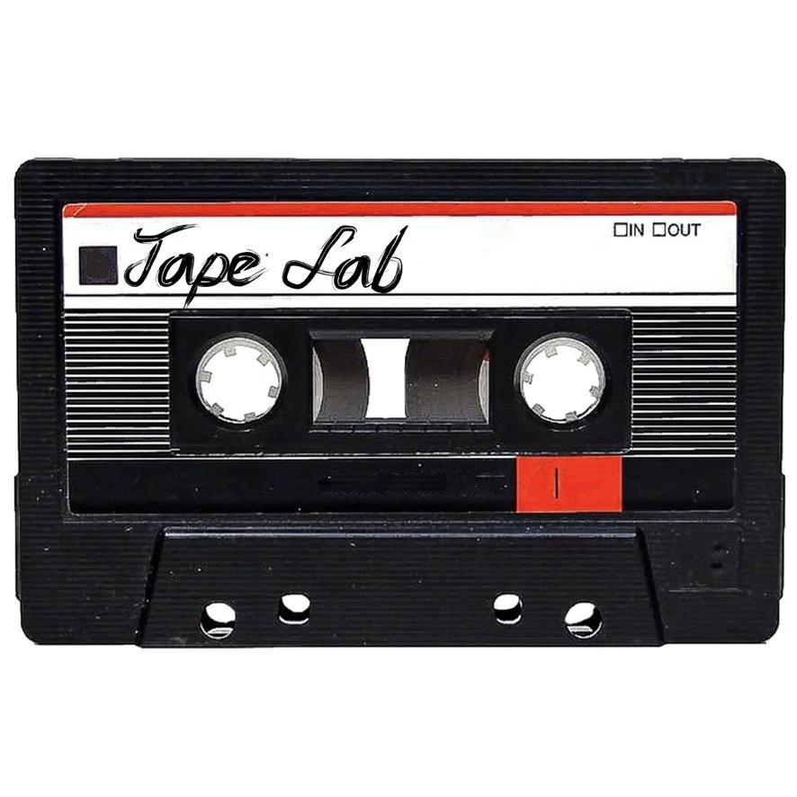 A vintage cassette tape with "Tape Lab" written on the label. The design includes red and black accents and displays "IN OUT" in the top right corner.
