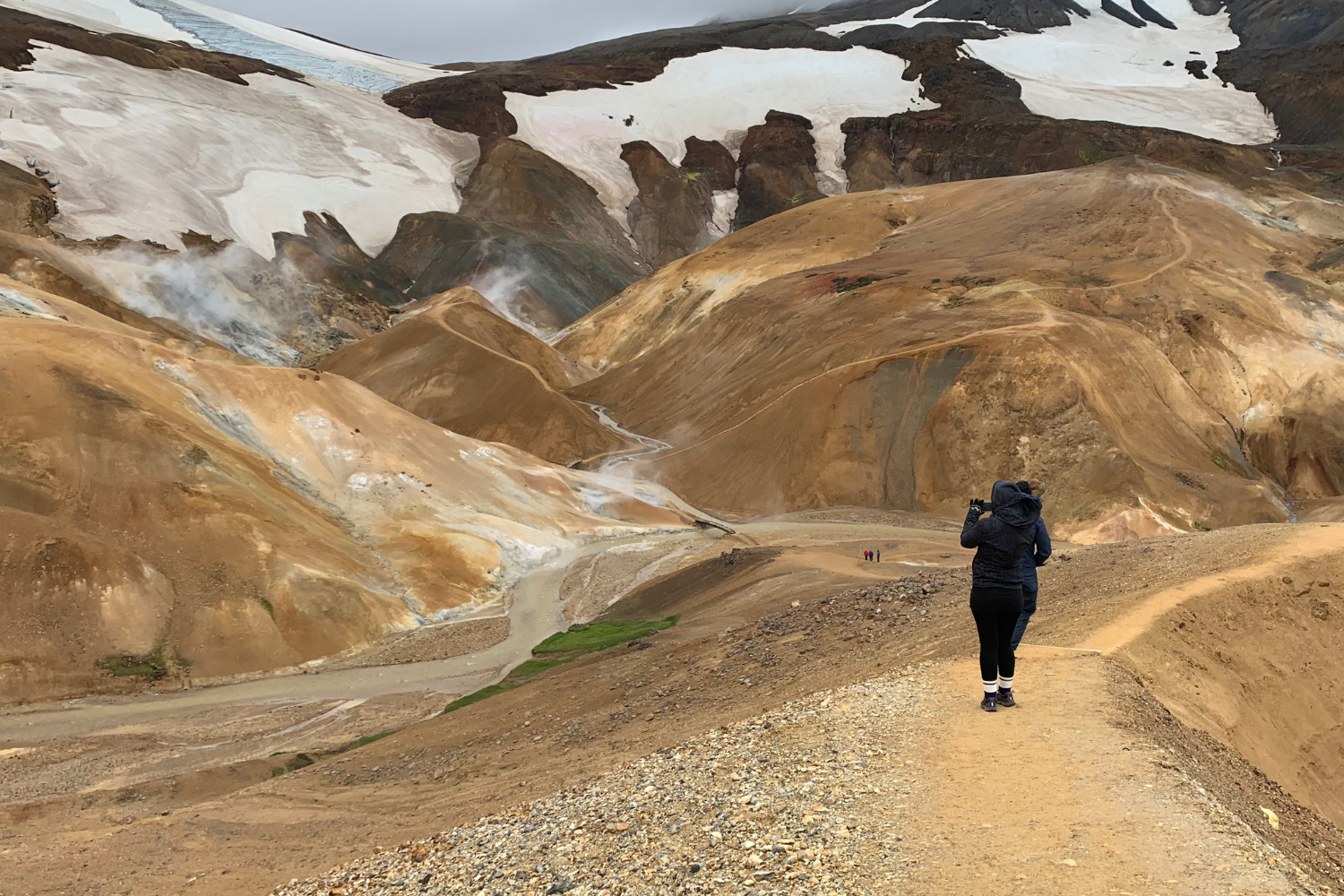 Traveller walking through the Hveradalir geothermal landscape