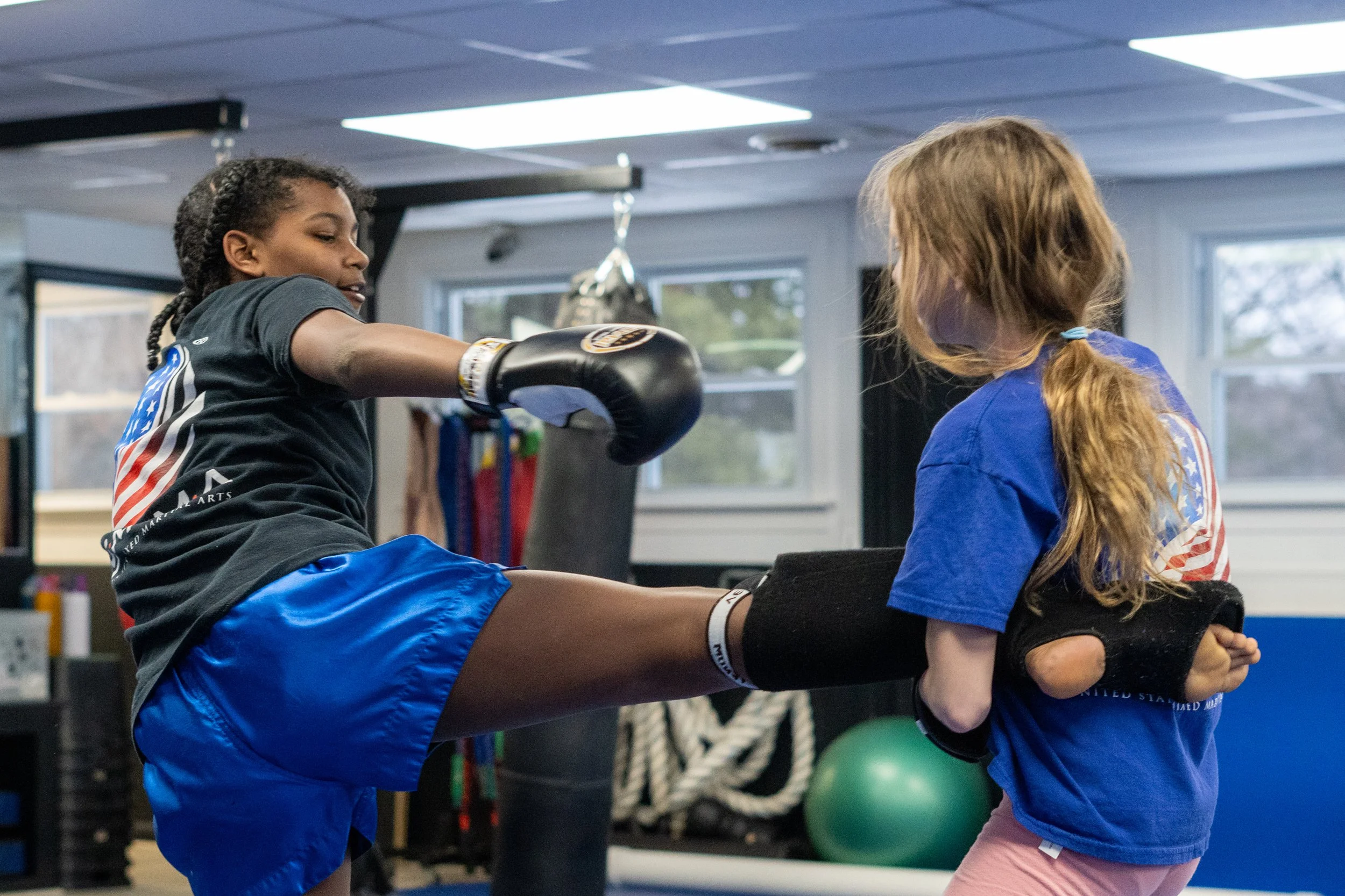 Two people wrapping hands with boxing wraps in a gym setting.