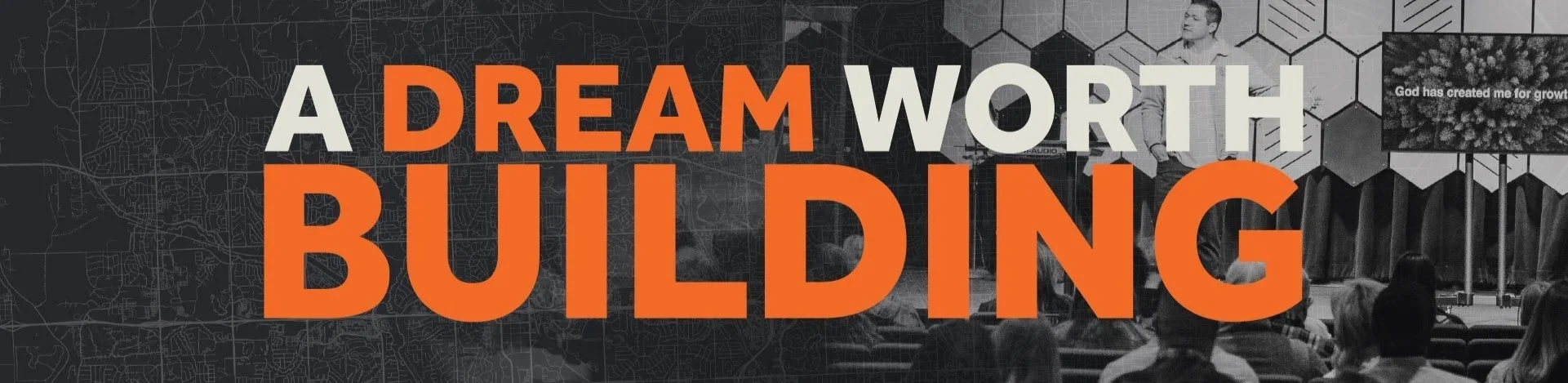 A banner with the text "A Dream Worth Building" in large bold letters, with a background showing a stage with an audience, a person speaking, and a wall with geometric patterns, overlaid on a map of a city.