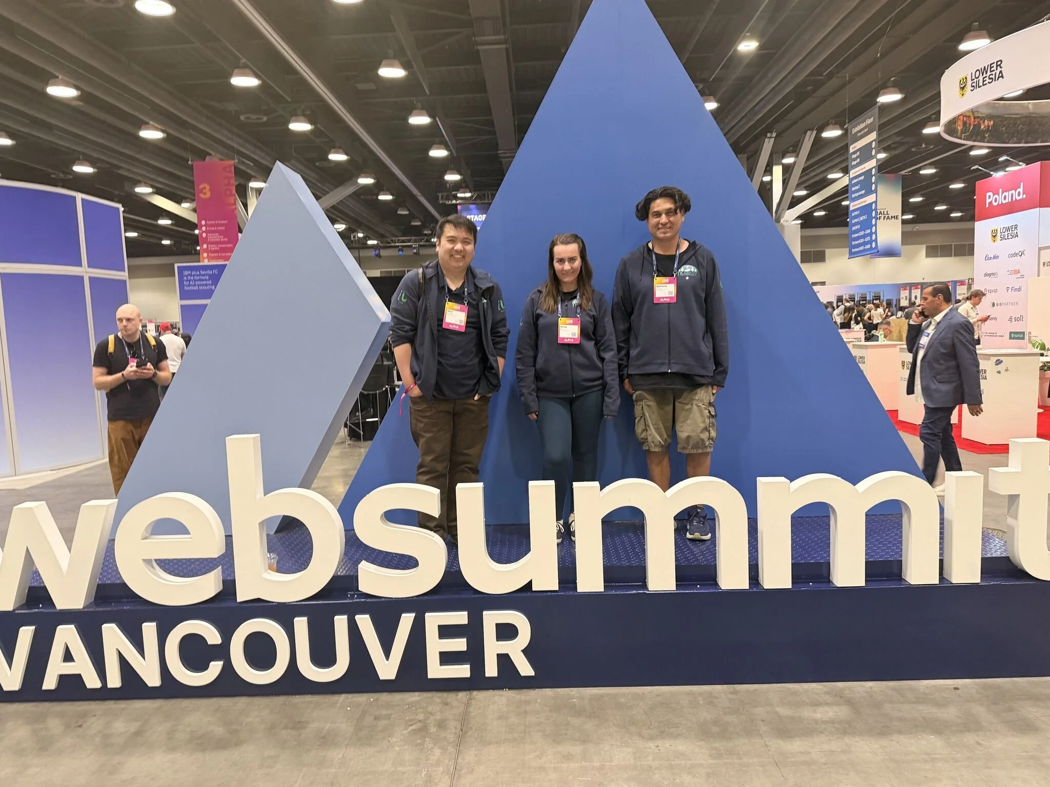 Noel Peralta, Jr., Anna Munson and Matt Munson behind the Web Summit Vancouver sign at the 2026 event.