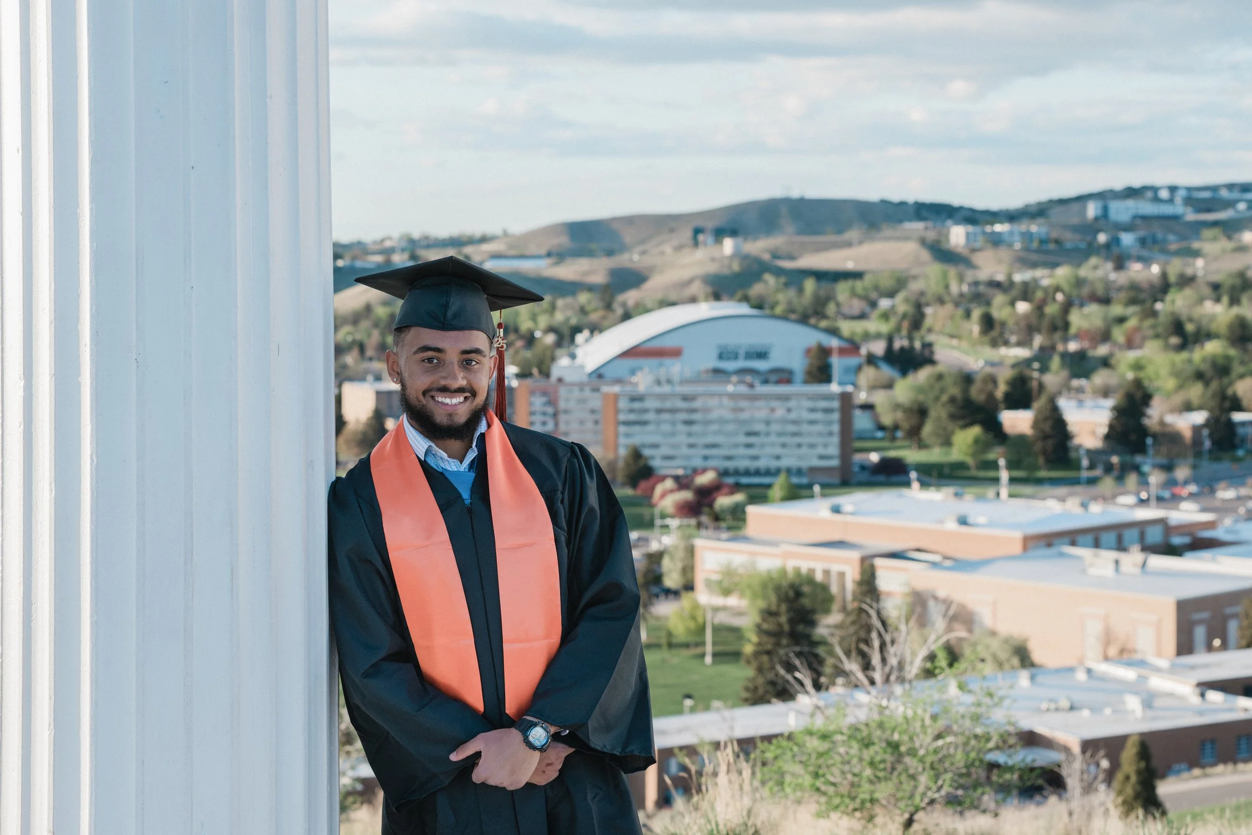 mans standing at the pillars in a graduation shoot at isu