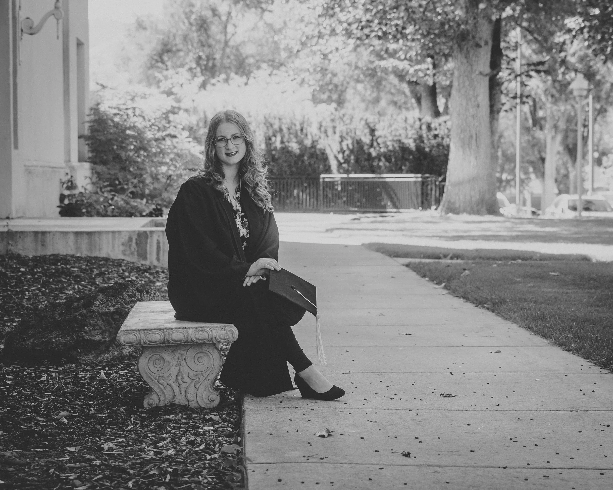 black and white portrait of a women sitting on the bench at idaho state university in pocatello idaho getting her graduation photoshoot done