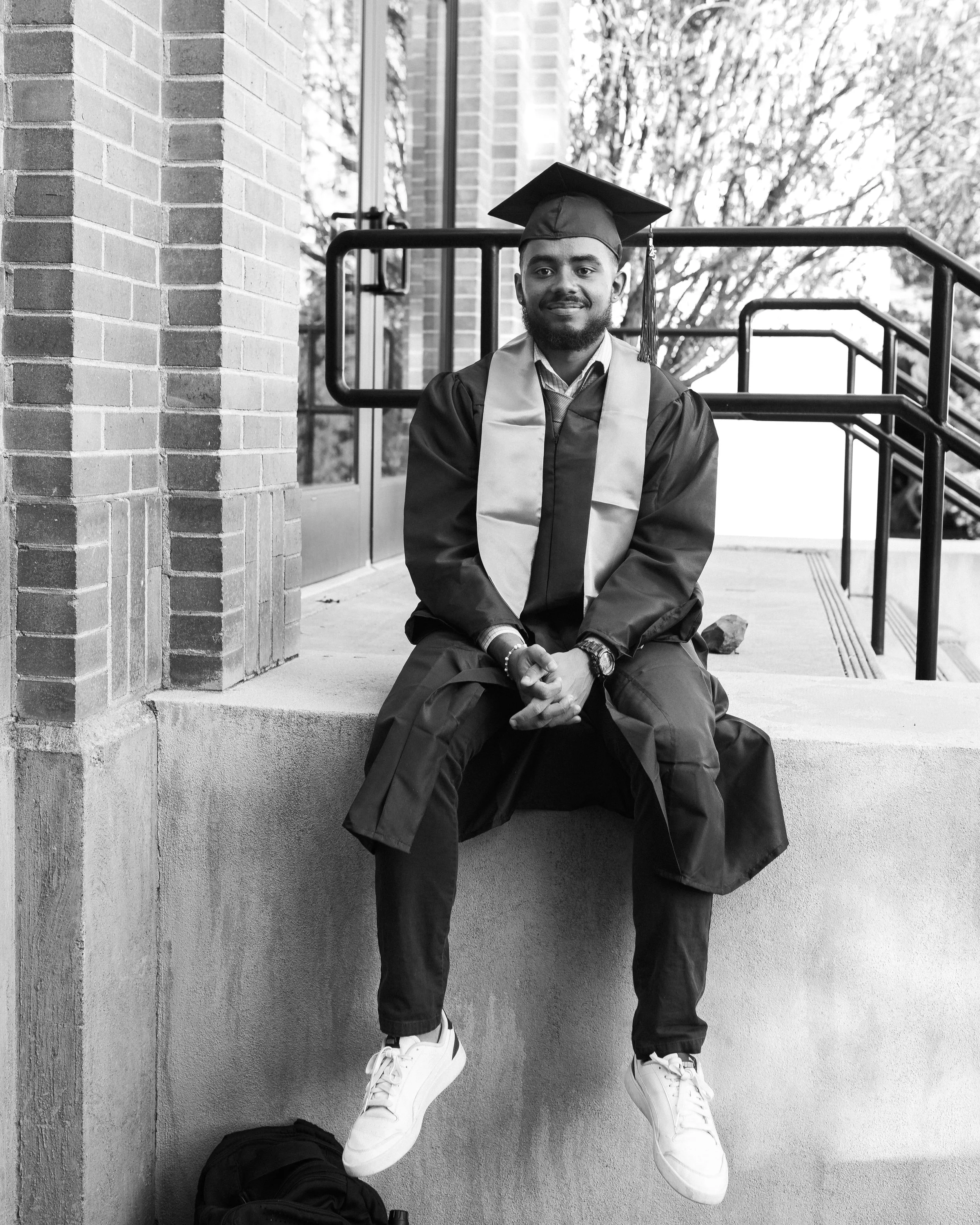 black and white photo of a man sitting on the curb at idaho state university