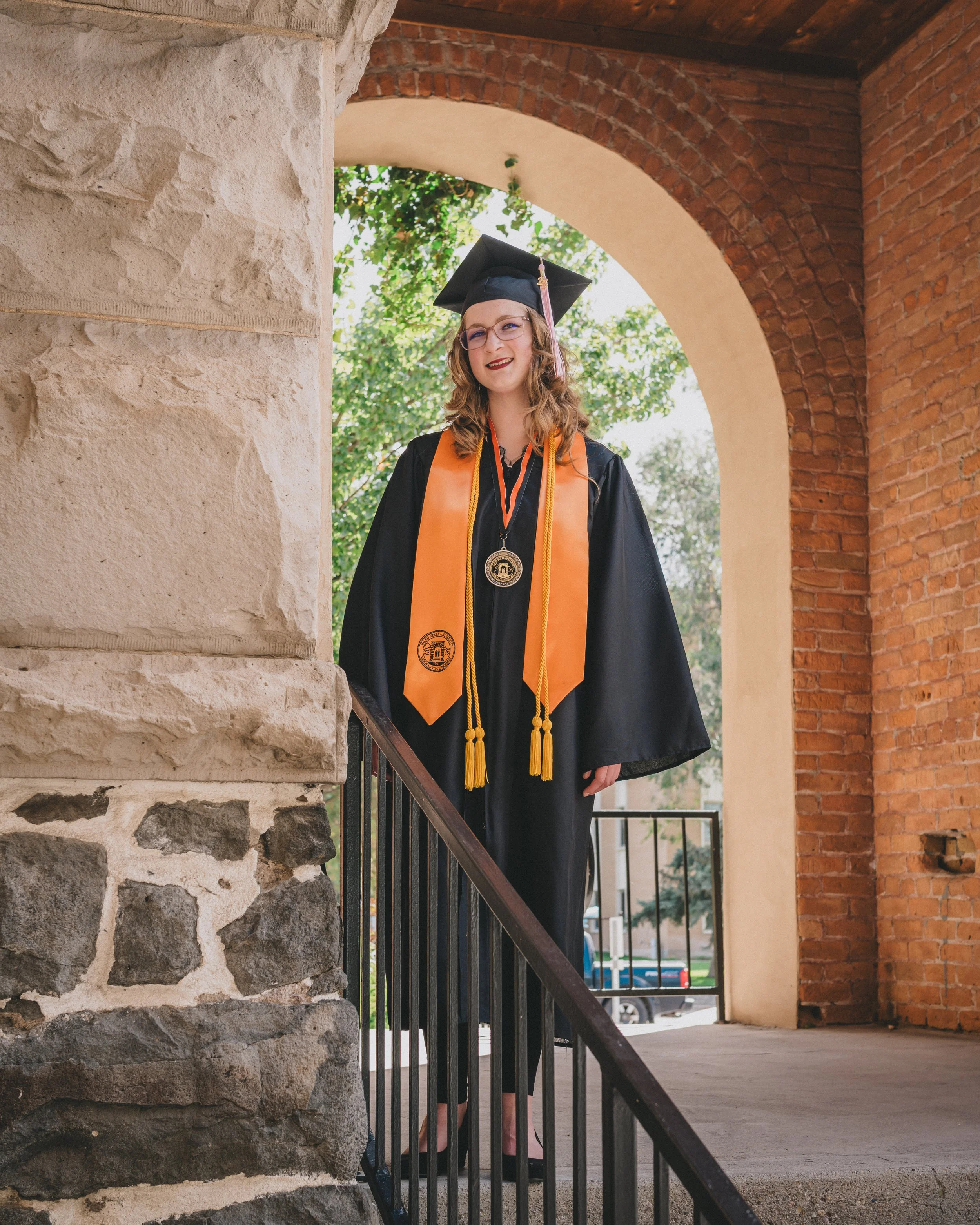 women on campus at idaho state university getting her graduation photoshoot done at at the arch